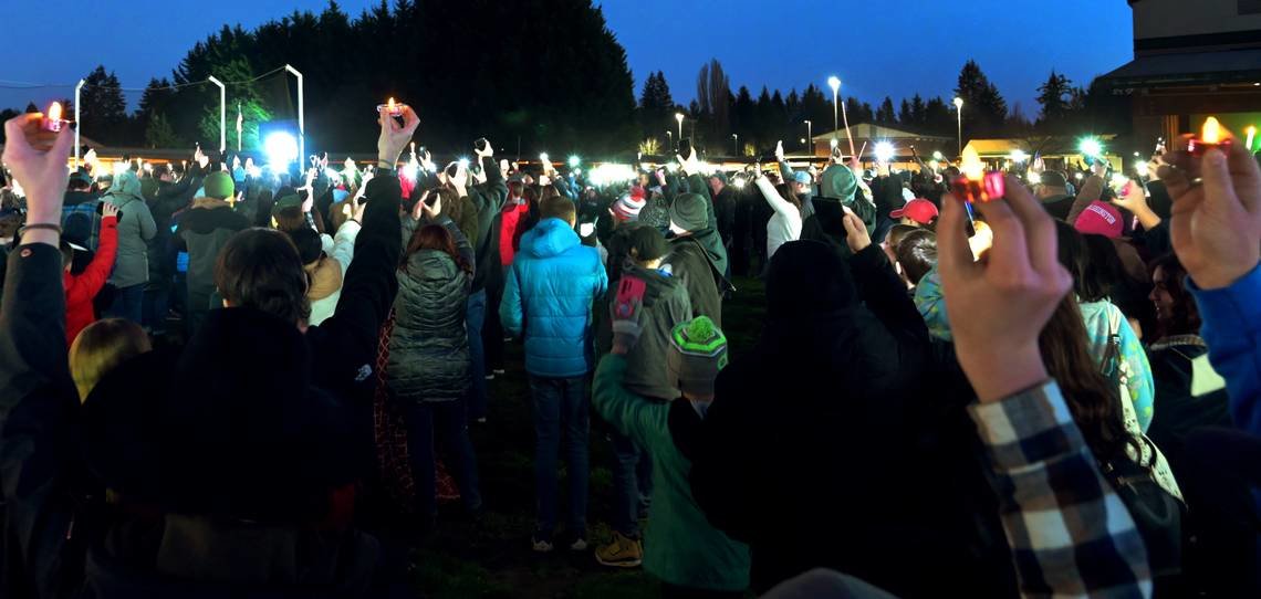 Hundreds of people hold battery-powered candles and lighted cell phones for a moment of silence at the conclusion of a Sunday evening, Jan. 29, gathering behind Tumwater Stadium to remember the five Cox family members who died in a house fire on Jan. 21 at Sherman Valley Ranch near Capitol Forest.