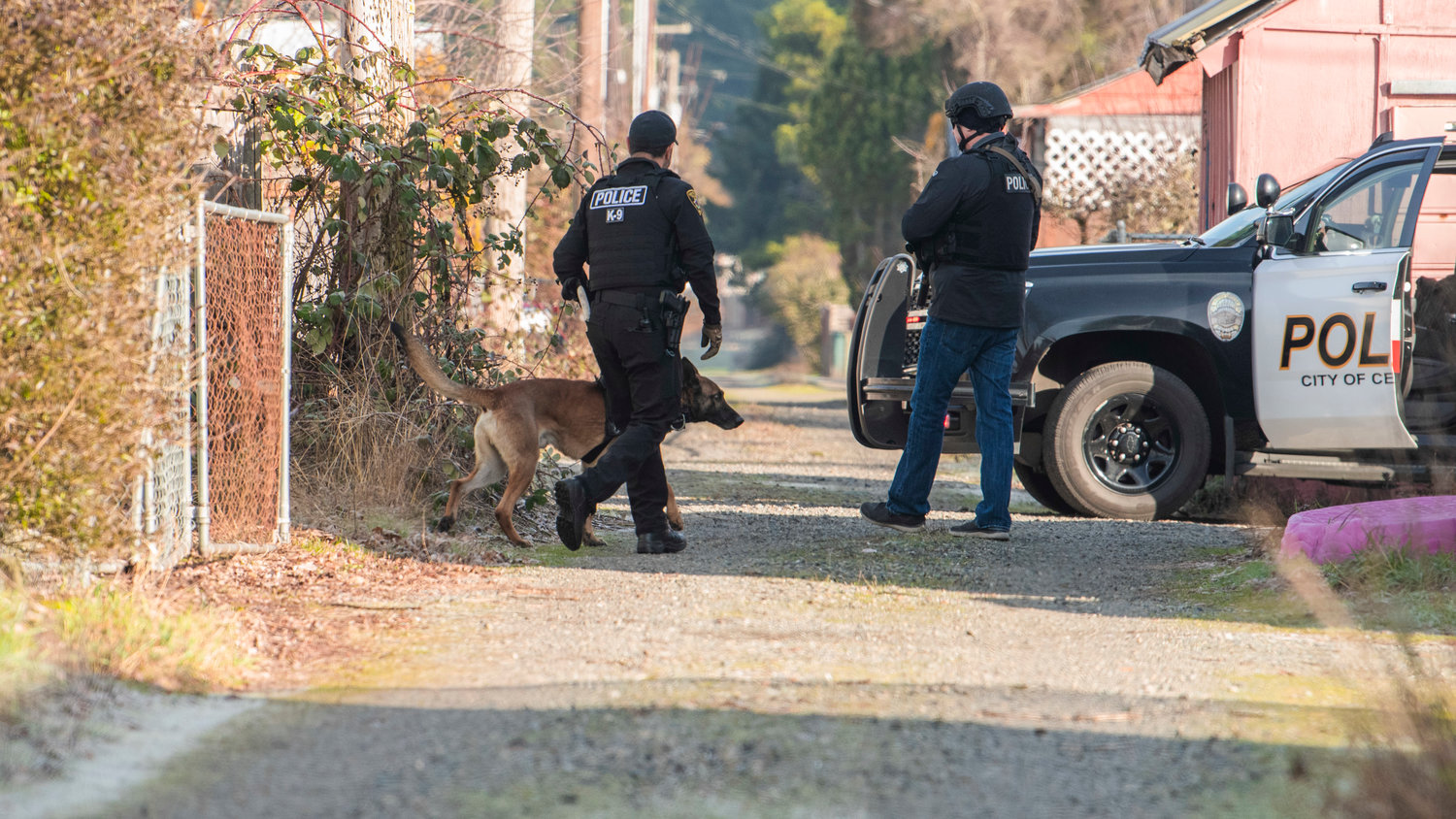 Centralia Police K9 Unit Officer Ruben Ramirez walks his dog around the scene of an active situation where a man barricaded himself in a building along Windsor Avenue in Centralia on Thursday.