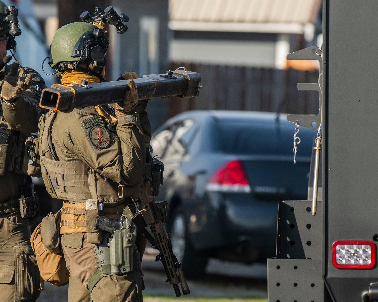 SWAT members attach a gas delivery system to a Washington State Patrol vehicle in the 1300 block of Windsor Avenue in Centralia on Thursday.