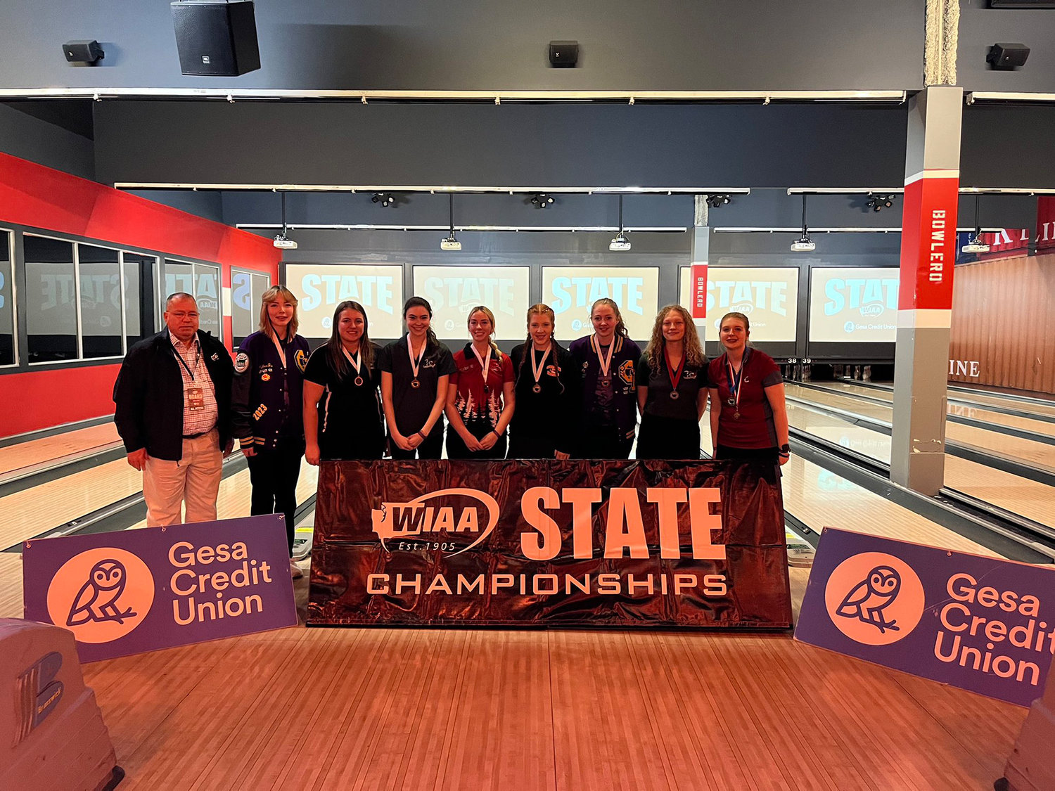W.F. West’s Piper Chalmers (right right) and  Centralia’s Bailee Spriggs (fourth from right) pose for a photo with the top eight individual placers at the 1A/2A girls bowling state championships Friday night  in Tukwila.