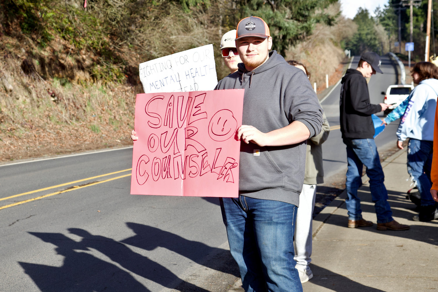 Winlock High School Senior Austin Allen holds up a sign during a protest against the Winlock School District’s plan to lay off two school counselors in Winlock on Wednesday.