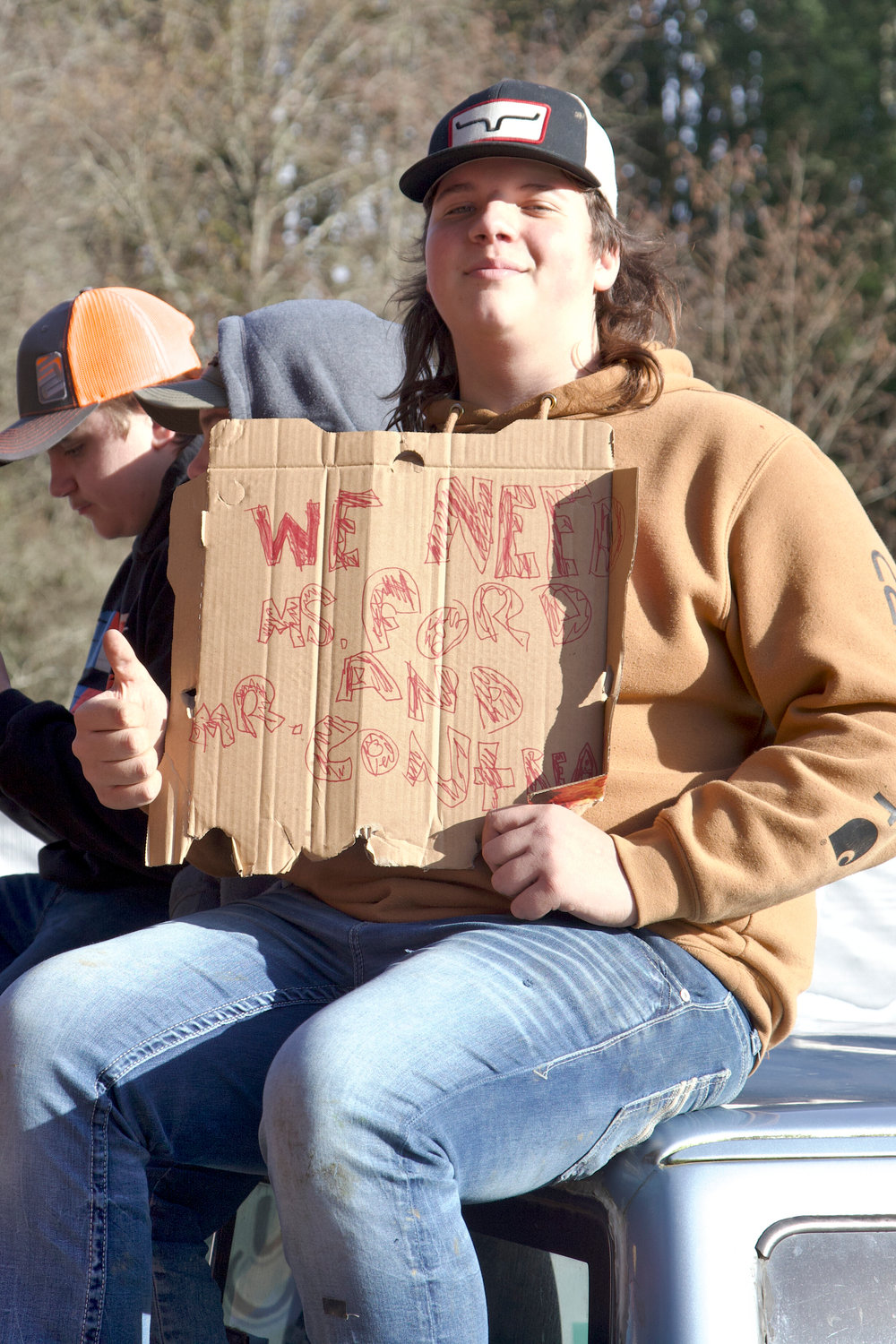 A Winlock student gives a thumbs up while holding a sign reading “We Need Ms. Ford and Mr. Contreras” during a protest against the Winlock School District’s plans to lay off two school counselors in Winlock on Wednesday.
