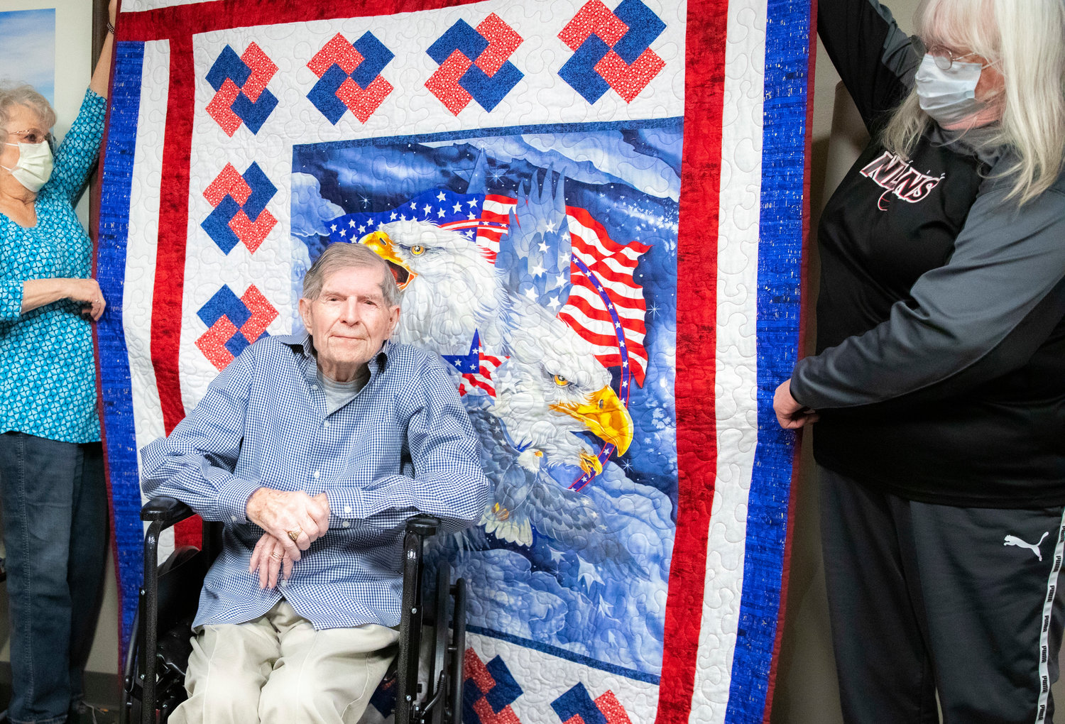 James F. Van Ackeren, a WWII veteran who served as a staff sergeant in the U.S. Army, is presented with a blanket from Quilts of Valor at Woodland Estates in Chehalis on Thursday.