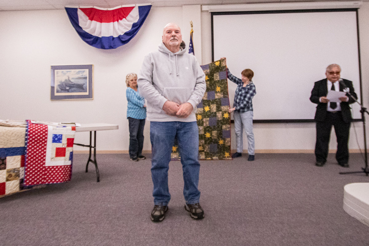 Members of the Veterans Memorial Museum chapter of Quilts of Valor prepare to give Army veteran Gary Langford his handmade quilt in recognition of his service at the museum Thursday afternoon.