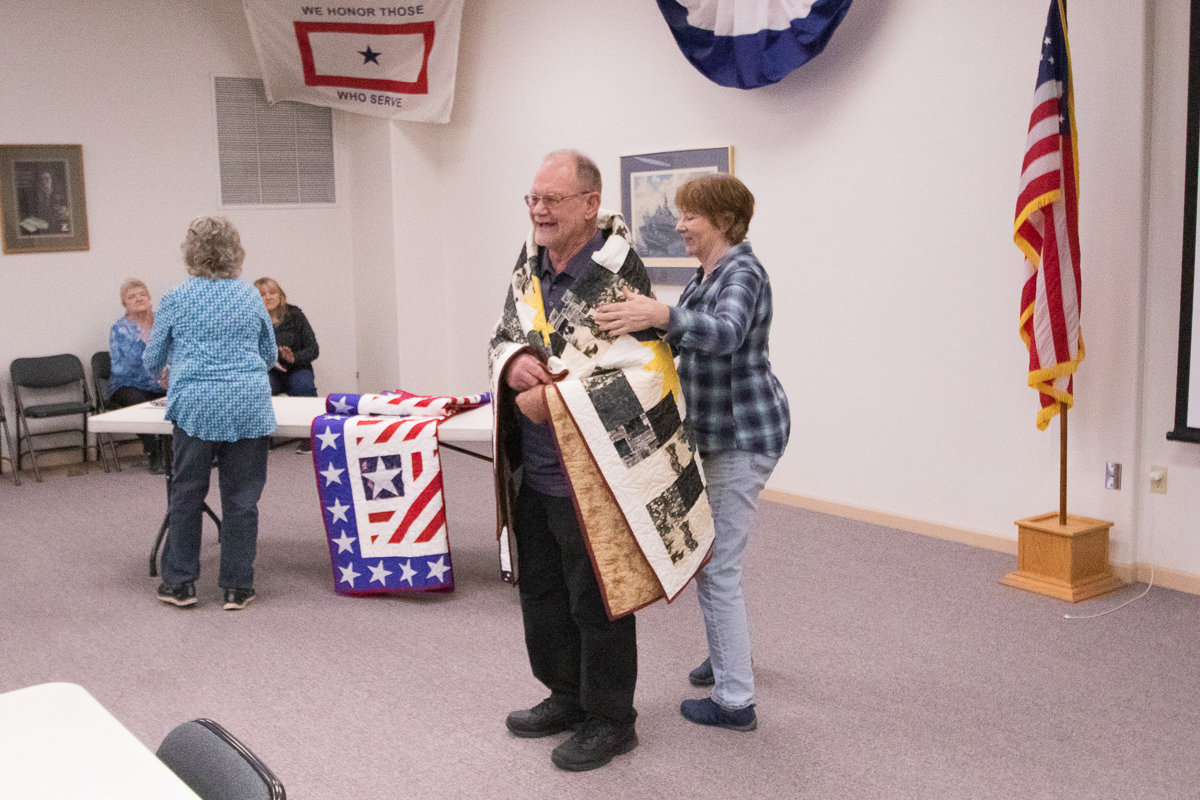 Army veteran Mel Kortlever recieves his handmade quilt from the Veterans Memorial Museum Quilts of Valor chapter on Thursday afternoon.