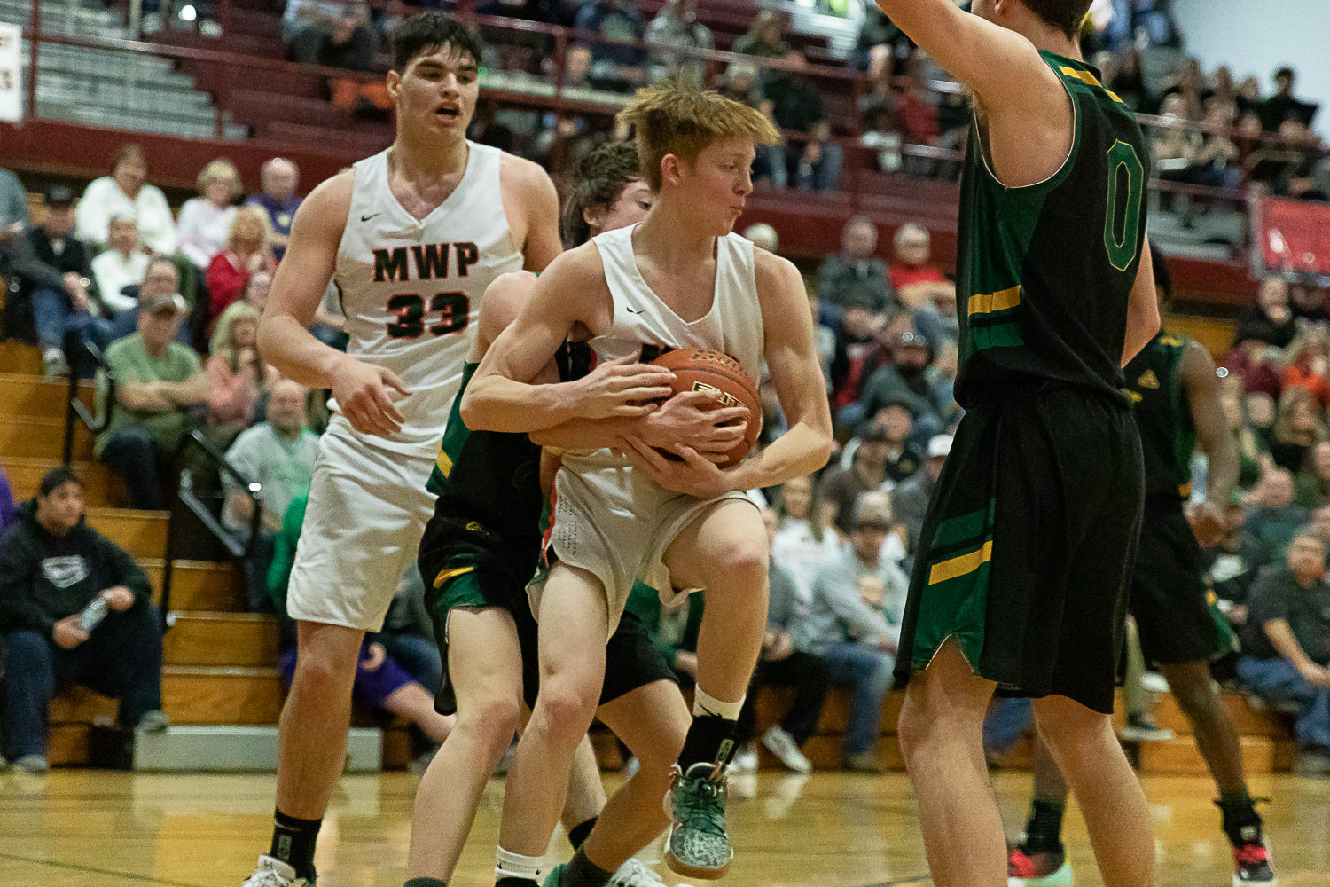 Morton-White Pass guard Jake Cournyer is bear-hugged in an opening round of state matchup against Northwest Christian (Colbert) at W.F. West Feb. 25.