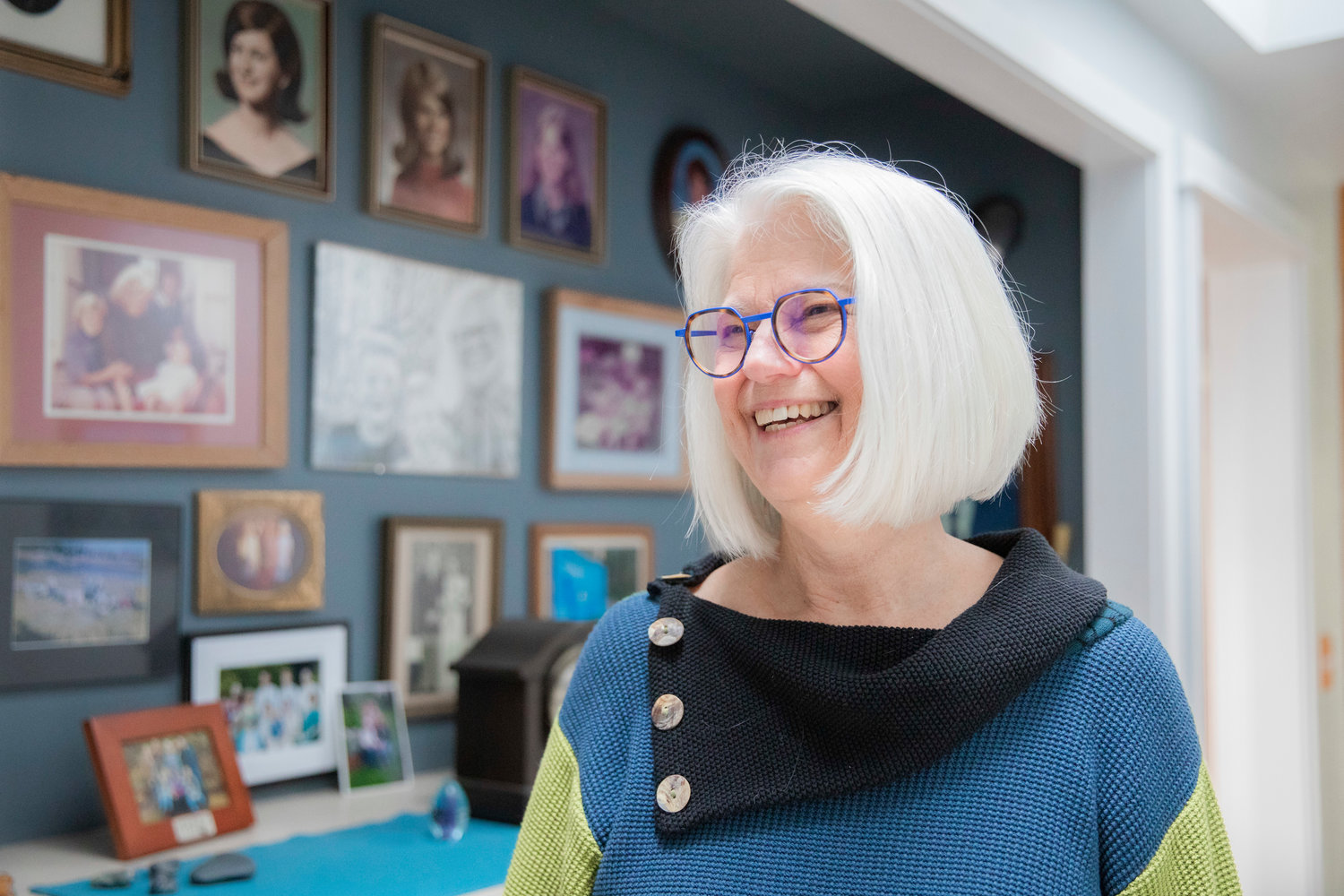 Gretchen Staebler smiles while talking about family in front of a wall full of portraits at her home off Seminary Hill Road in Centralia.
