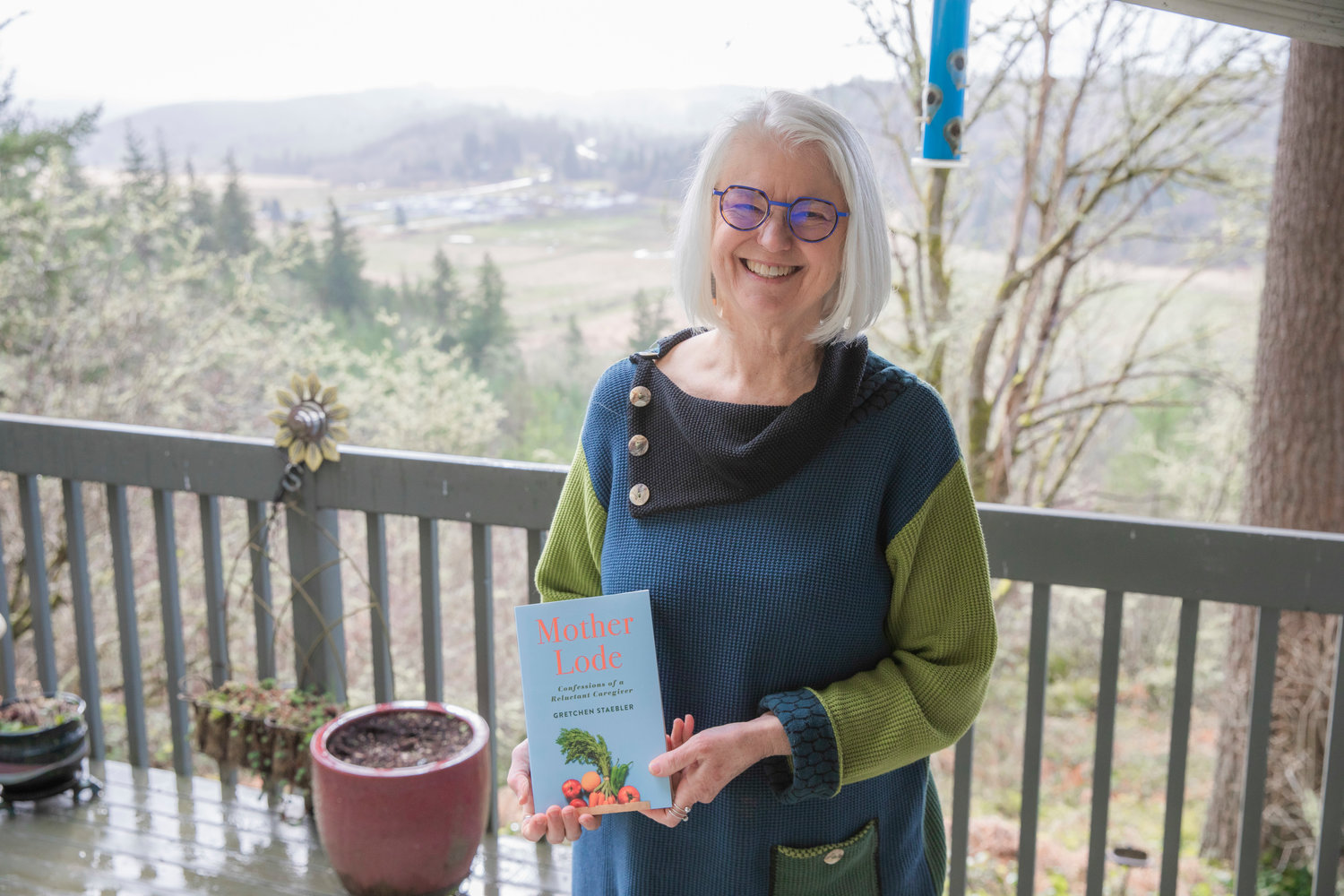 Gretchen Staebler smiles for a photo with her book titled “Mother Lode, Confessions of a Reluctant Caregiver” at her residence off Seminary Hill Road in Centralia.