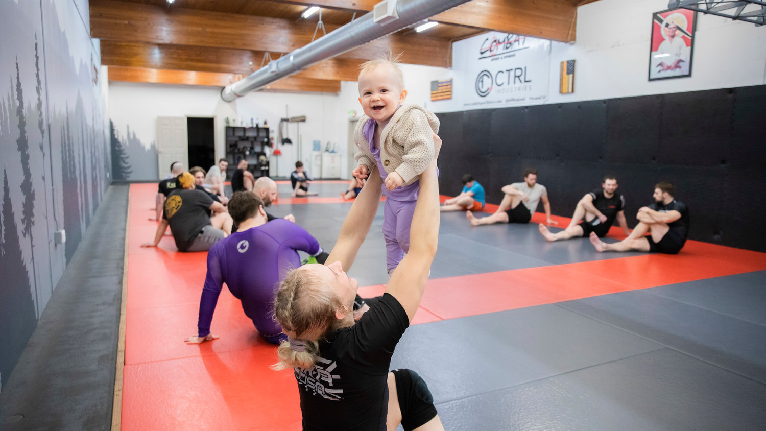 Kayla Weed, a W.F. West graduate, smiles holds up her 1-year-old daughter Mia inside Combat Sport and Fitness in Enumclaw on Thursday while training for her upcoming fight on March 11, at the Muckleshoot Casino.