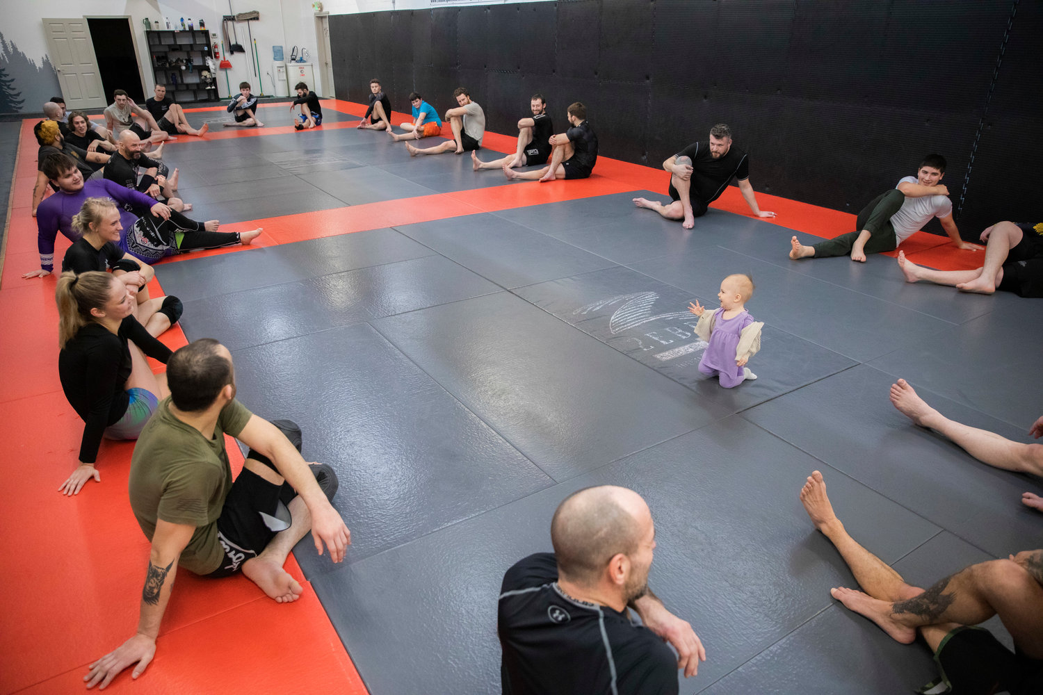 Kayla Weed, a W.F. West graduate, smiles at her 1-year-old daughter Mia inside Combat Sport and Fitness in Enumclaw on Thursday as she stretches.