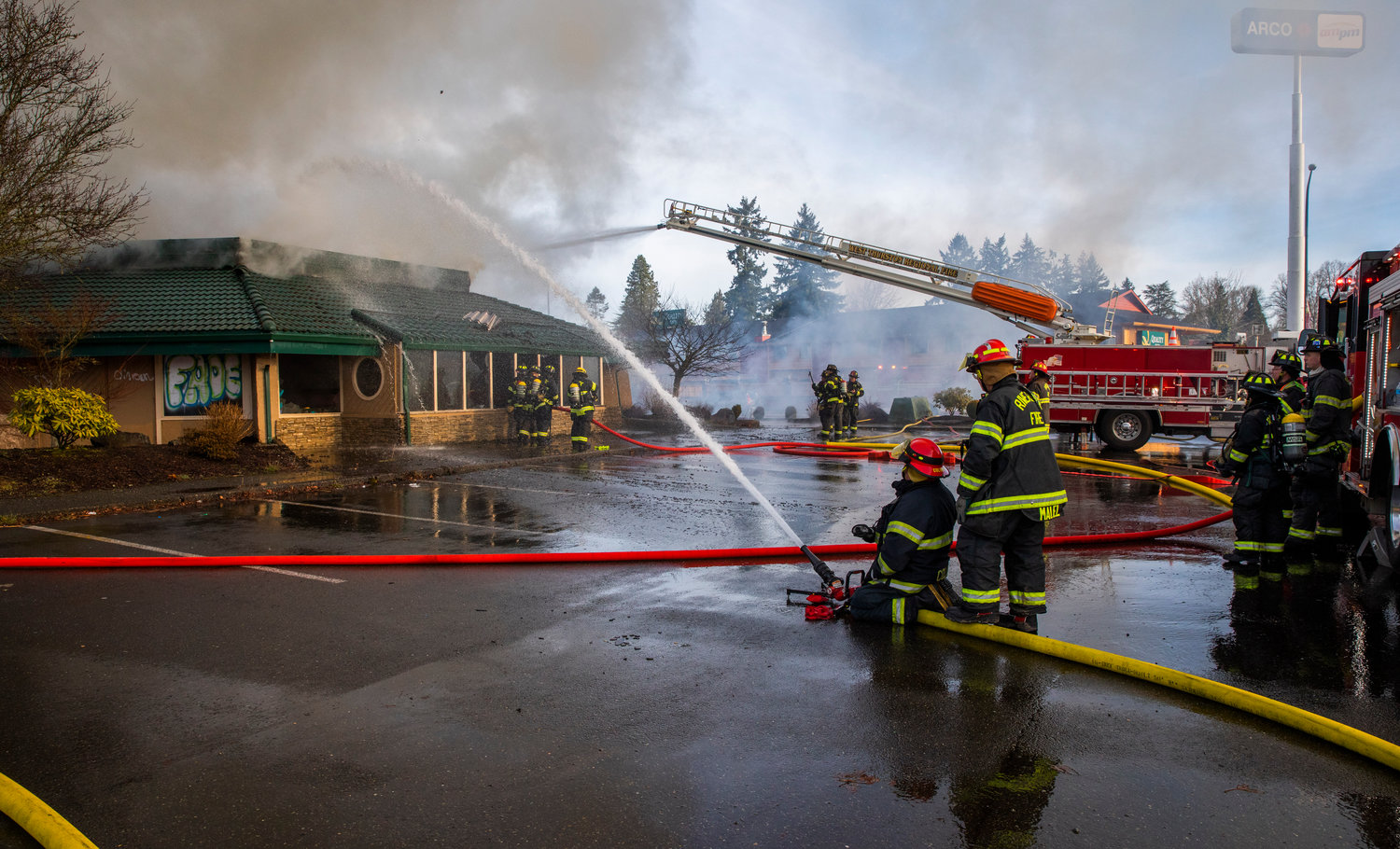 Crews work together to put out flames inside the former location of Papa Pete’s and Shari’s Cafe in Centralia on Sunday.