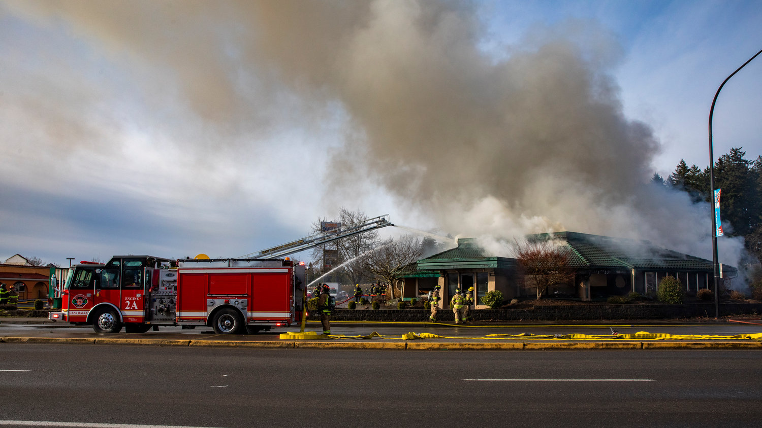 Smoke billows out from the former location of Papa Pete’s and Shari’s Cafe in Centralia as emergency crews respond to put out flames in the building on Sunday.