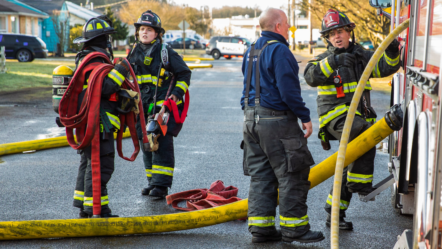 Crews from Riverside Fire Authority carry hoses along View Avenue in Centralia where a detached garage and items inside were damaged by flames Wednesday morning.