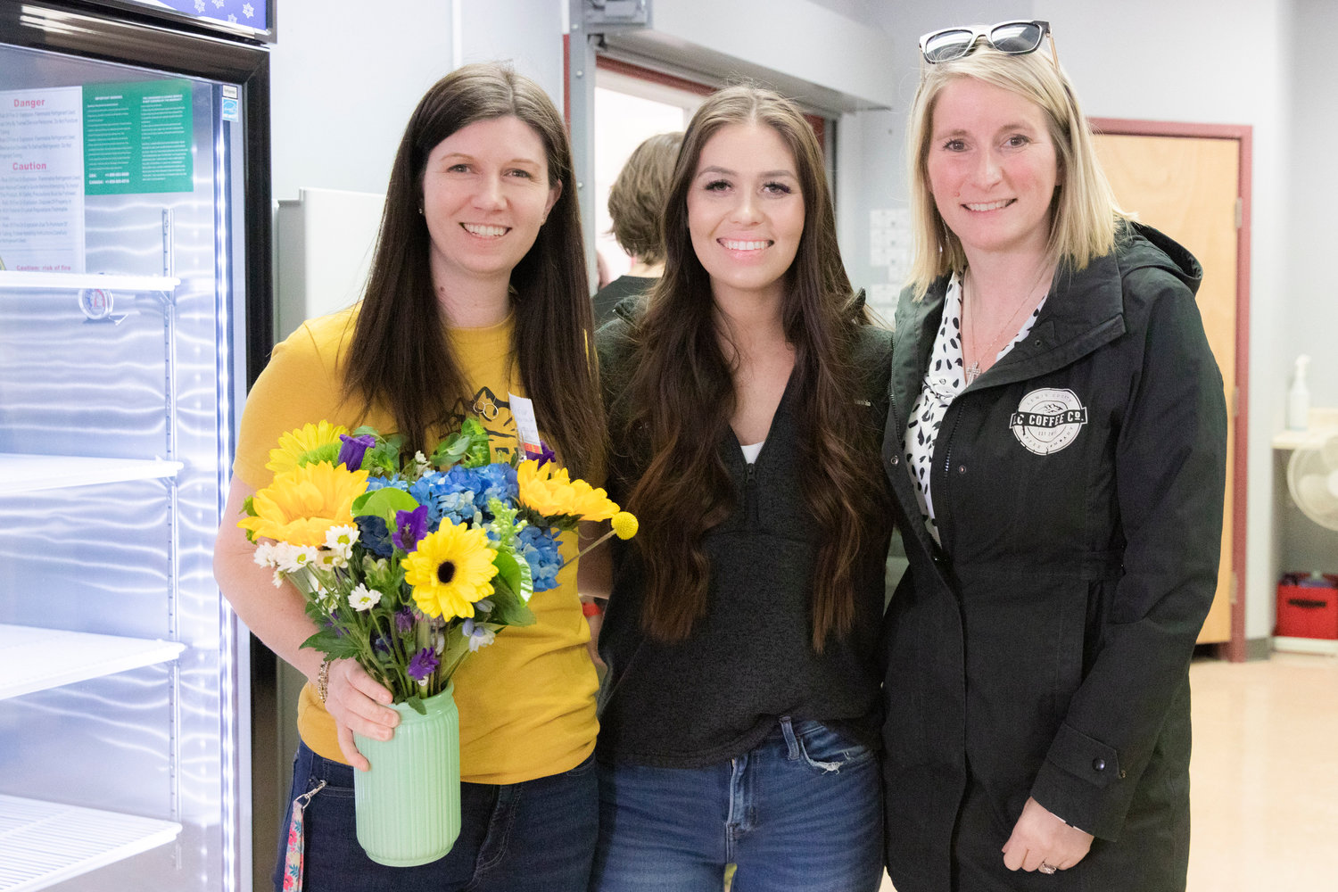 From left, Kristin Ciolli, Angie Twining and Sam Magnuson pose for a photo as Lewis County Coffee Co. celebrates a ribbon cutting ceremony on Wednesday for a new student store "The Crimson & Gray," at W.F. West High School in Chehalis.