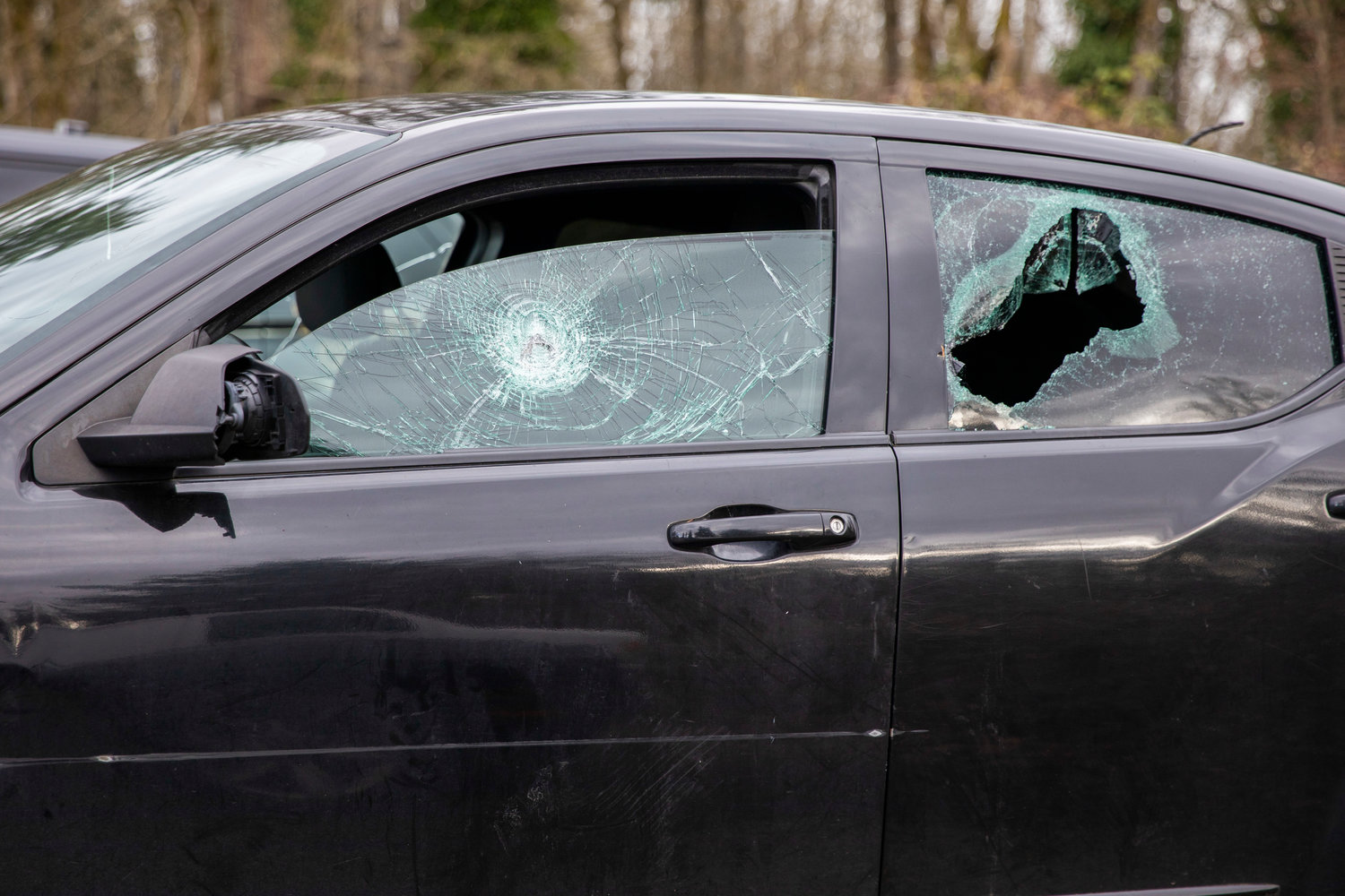 A car is seen with smashed windows near the site of an abandoned vehicle used in an armed robbery in Centralia on Wednesday.