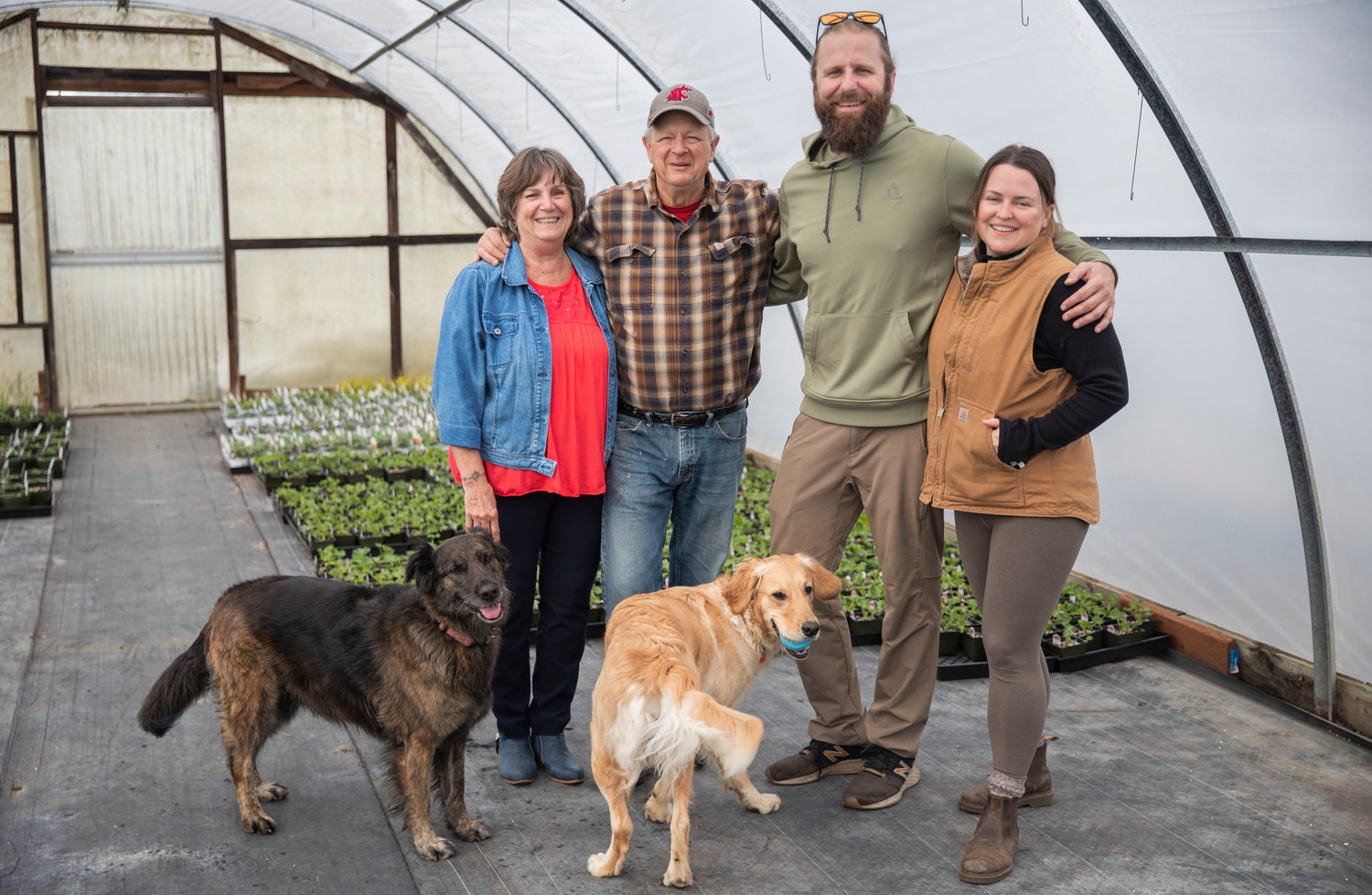 Connie and Spencer Davis pose for a photo alongside Kyle and Jena Aselton and their dogs Birdy and Willow at the Dirty Thumb Nursery along state Route 6 near Adna.