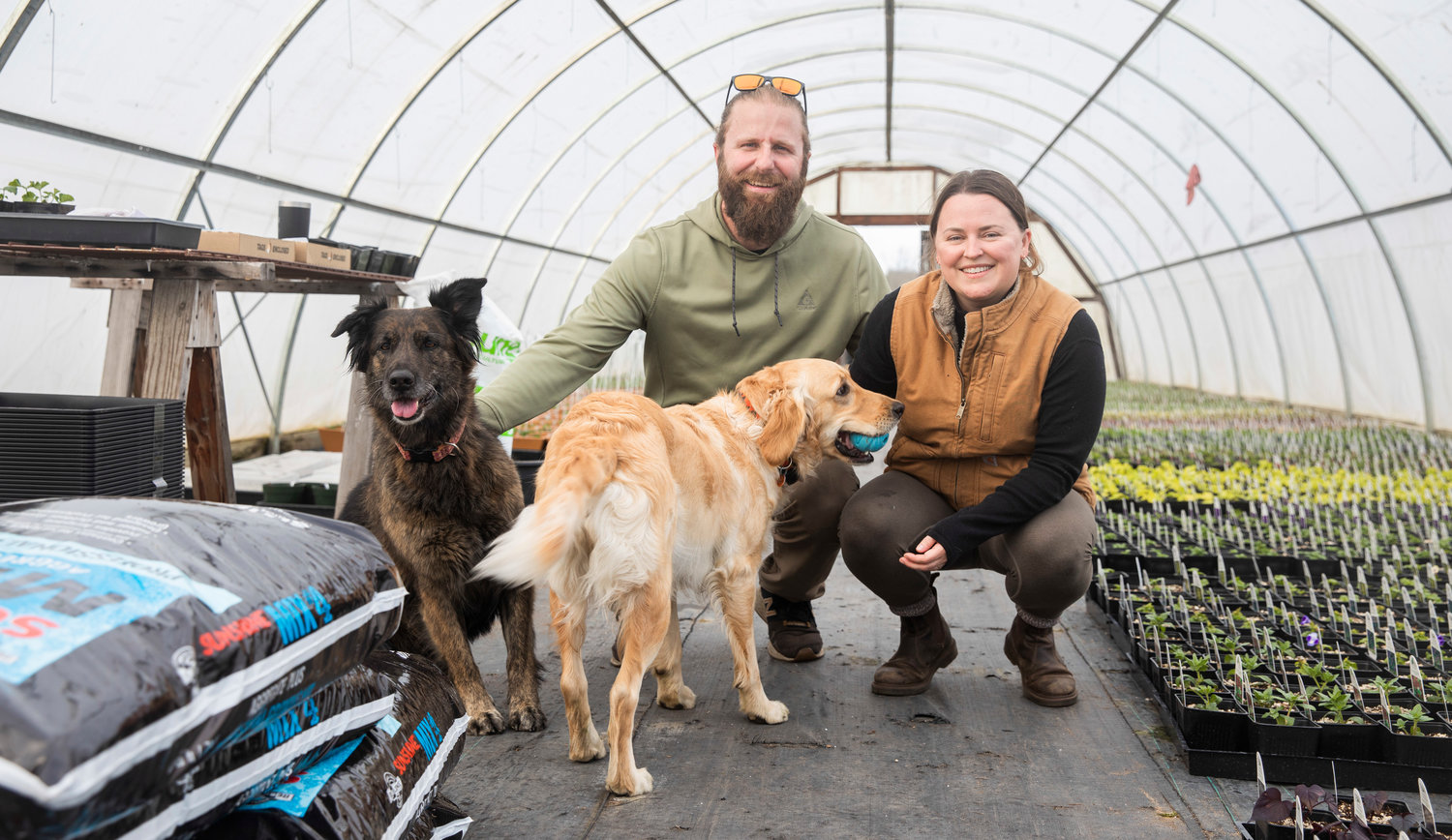 Kyle and Jena Aselton pose for a photo with their dogs Birdy and Willow at the Dirty Thumb Nursery along state Route 6 near Adna on Wednesday.
