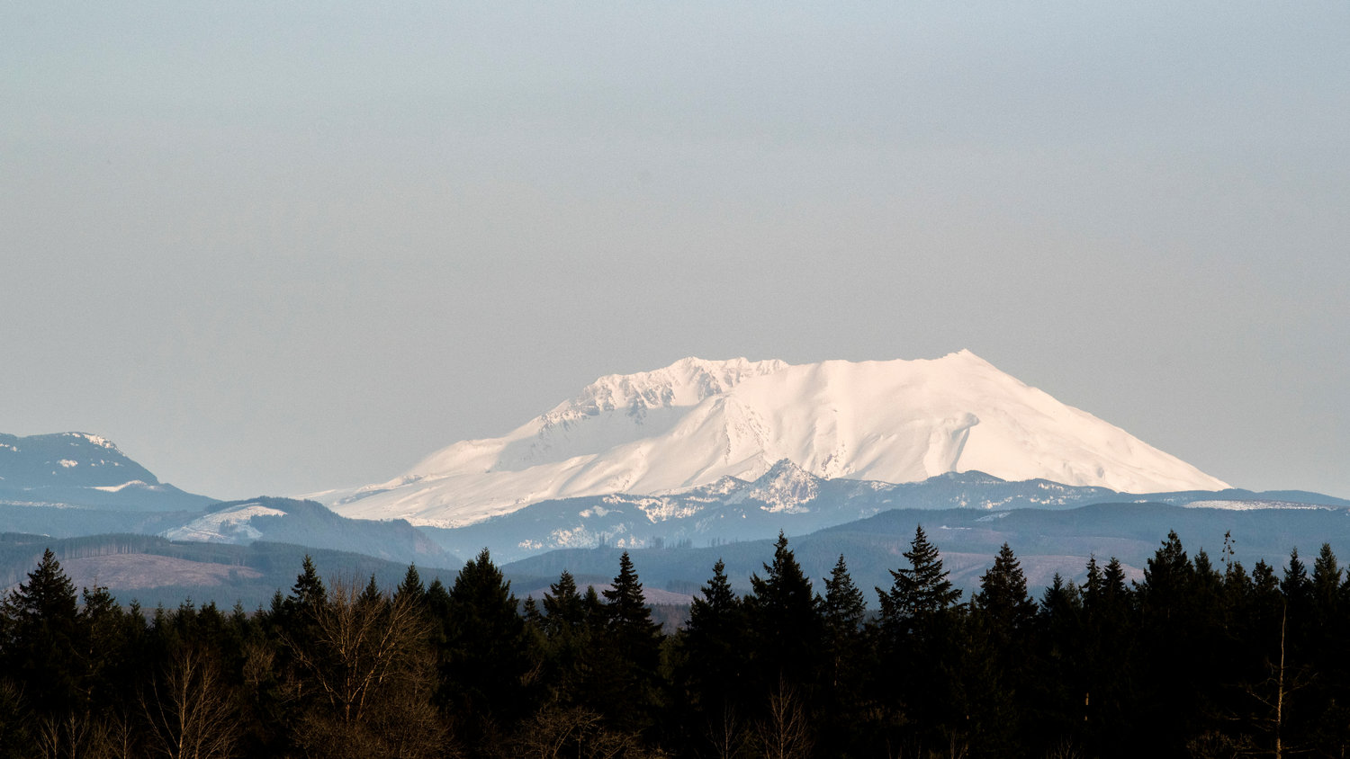 Mount St. Helens casts shadows on itself as the sun sets, as seen from between Toledo and Winlock on Thursday evening.