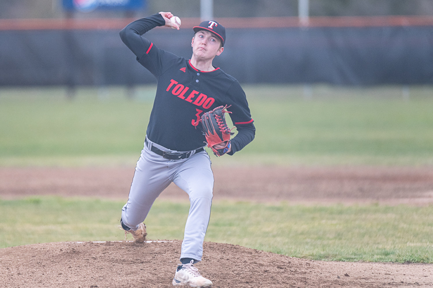 Caiden Schultz spins in a curveball during Toledo's game at Napavine on March 20.