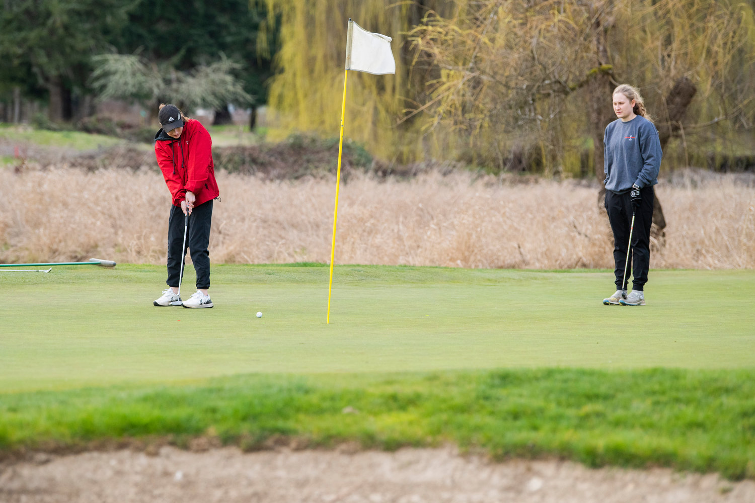 Centralia junior Emily Wilkerson watches as W.F. West junior Abby Alexander looks to put a ball in at Riverside Golf Course in Chehalis on Monday.
