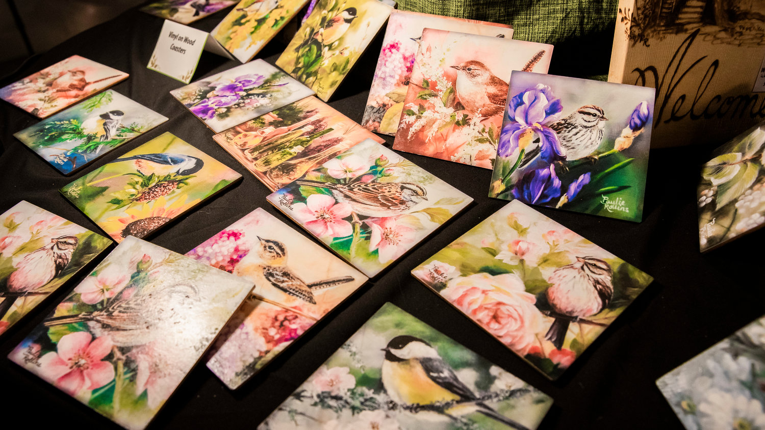 Paintings of birds by Paulie Rollins are illuminated during the Tenino Arts Spring Market featuring 32 regional artisans inside the Kodiak Room on Sunday.