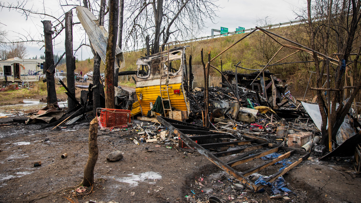 Charred debris are left Wednesday morning after a structure fire inside a homeless encampment near Blakeslee Junction on Tuesday, March 28, 2023.