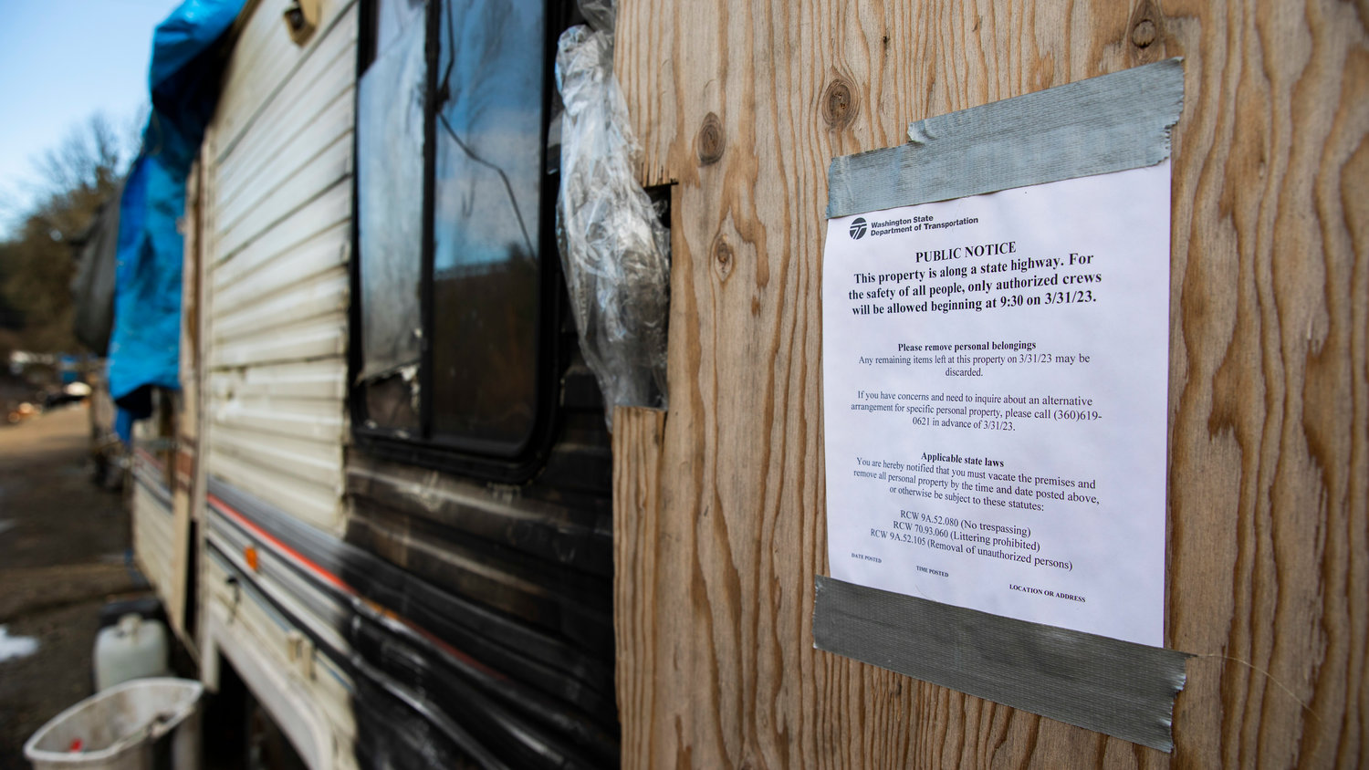 Signs from the Washington State Department of Transportation are seen displayed around a homeless encampment near Blakeslee Junction on Wednesday, March 29, 2023.