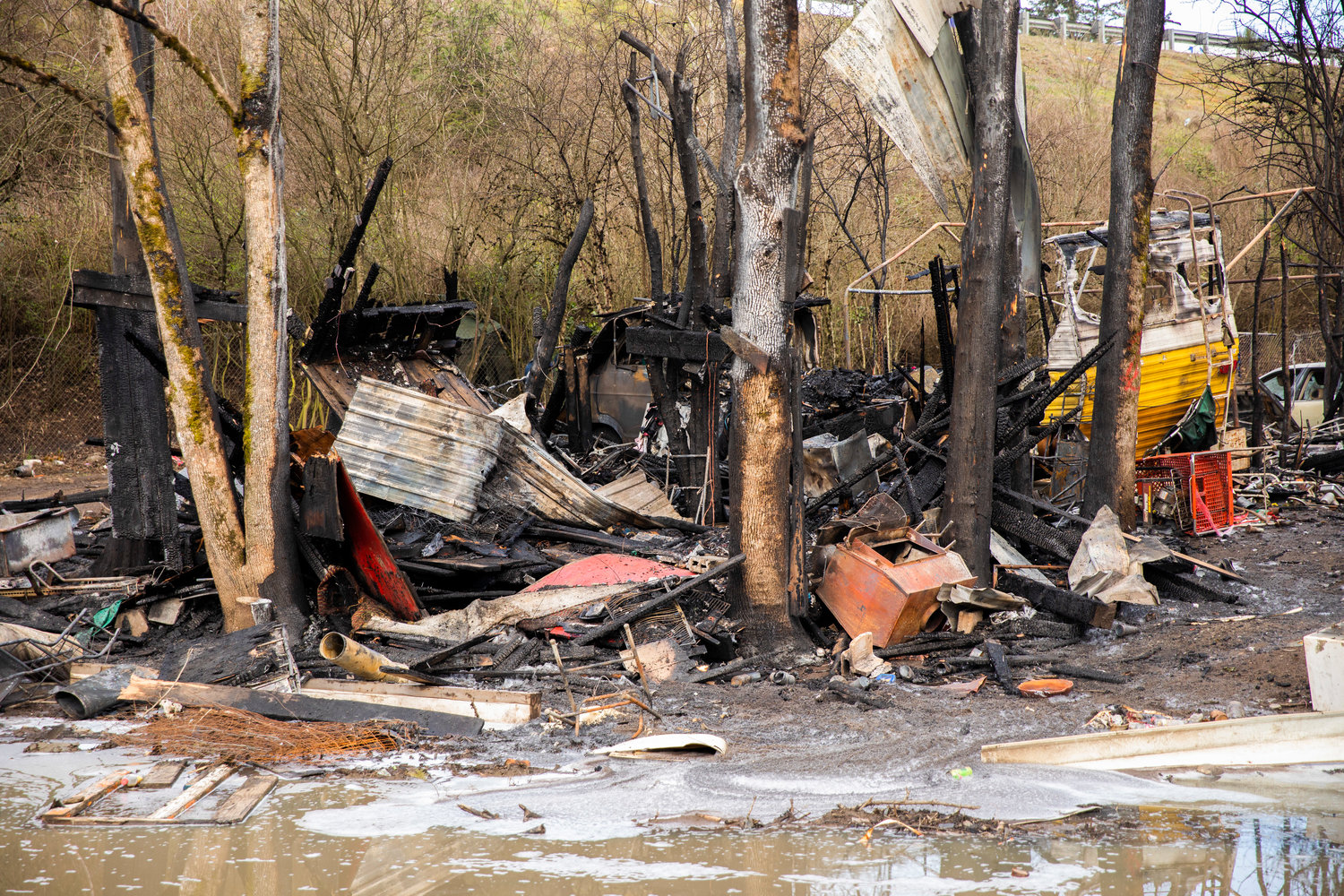 Charred debris are left Wednesday morning after a structure fire inside a homeless encampment near Blakeslee Junction on Tuesday, March 28, 2023.