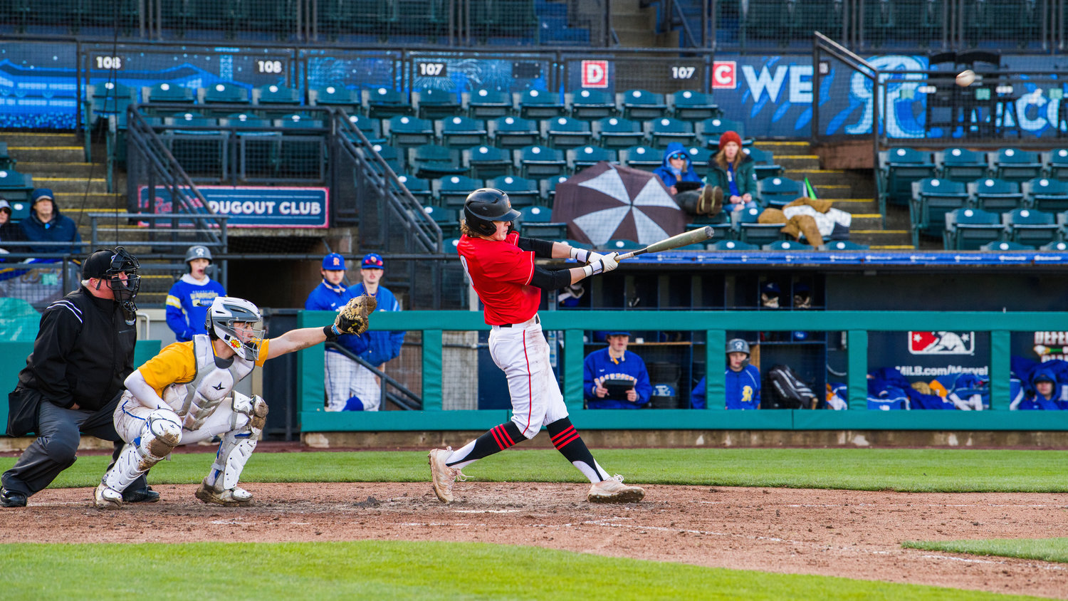 Tenino’s Kellan Knox (8) slams in a home run with a baserunner on at Cheney Stadium, home of the Tacoma Rainiers, during a Saturday afternoon game against Rochester.