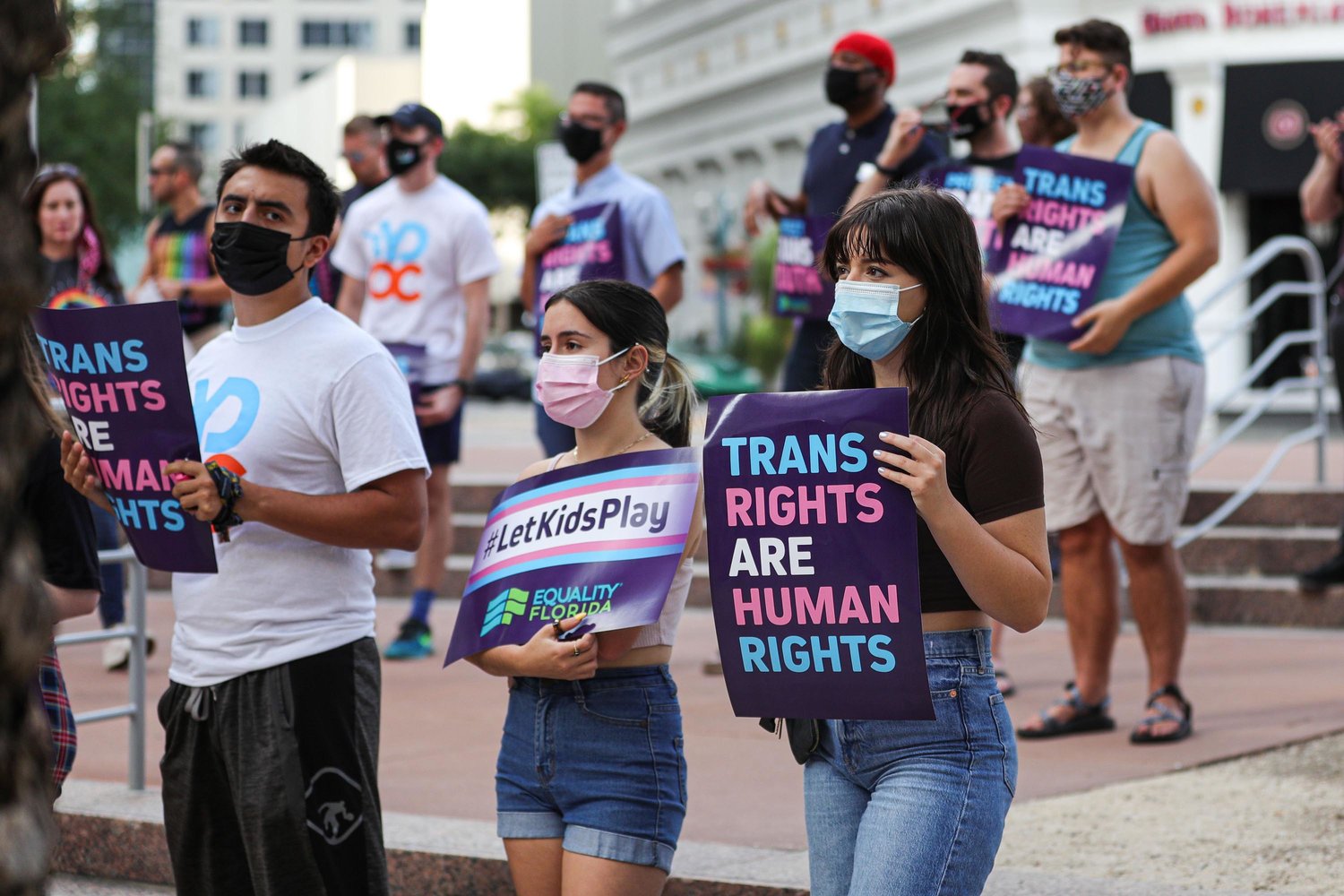 A group of attendees listen to a speaker during the #ProtectTransKids rally outside Orlando City Hall on June 1, 2021, in Orlando, Florida.