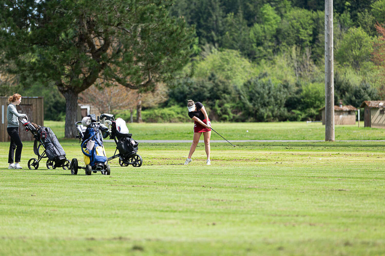 W.F. West's Natalie Eklund takes a shot while Centralia's Samanatha Johnston (left) looks on at Tumwater Valley May 9 in the 2A Evco Championships.