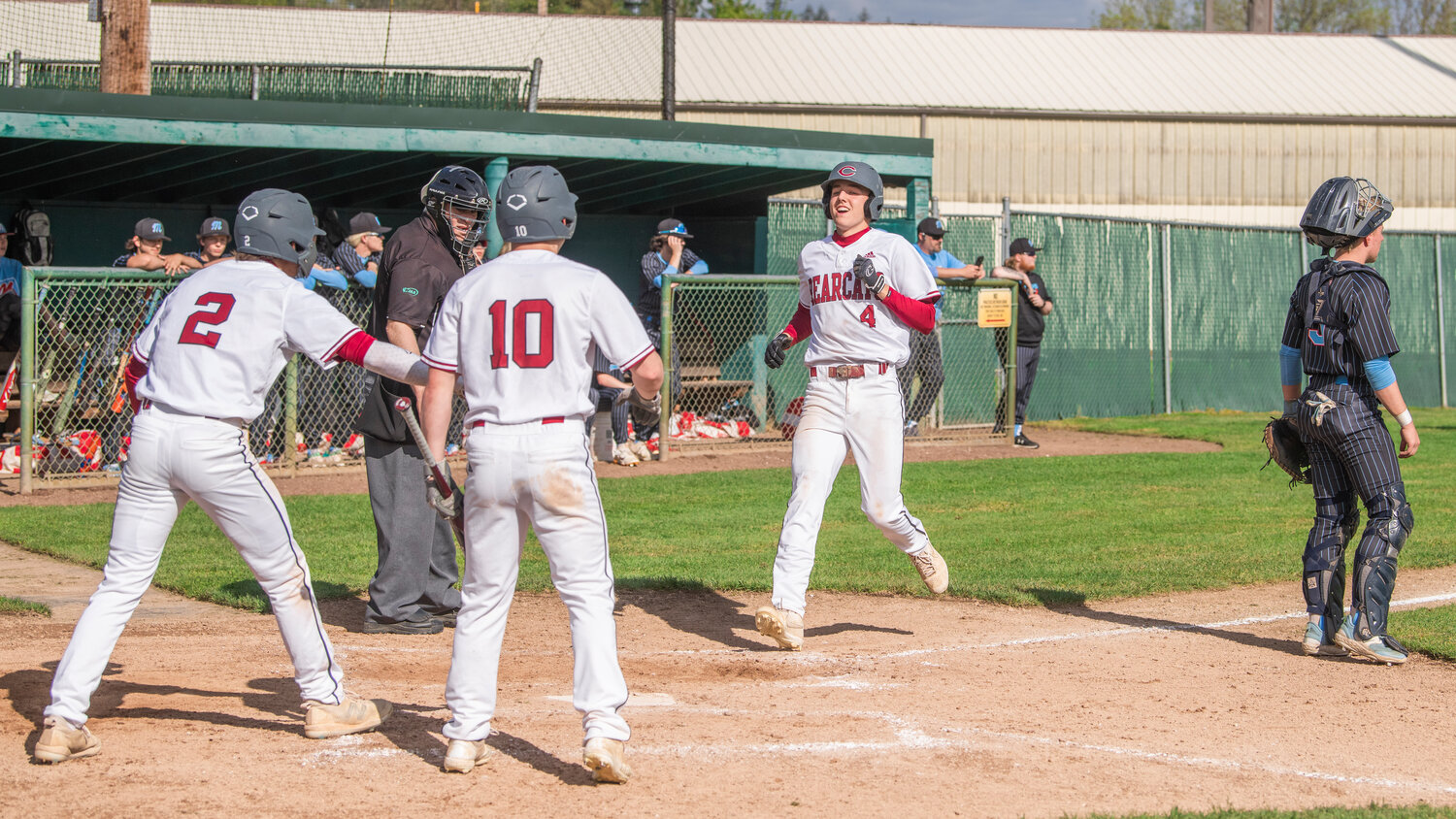 W.F. West’s Weston Potter (4) smiles as he prepares to celebrate with teammates while crossing home plate during a game against Mark Morris at Bearcat Stadium in Chehalis on Tuesday, May 9.