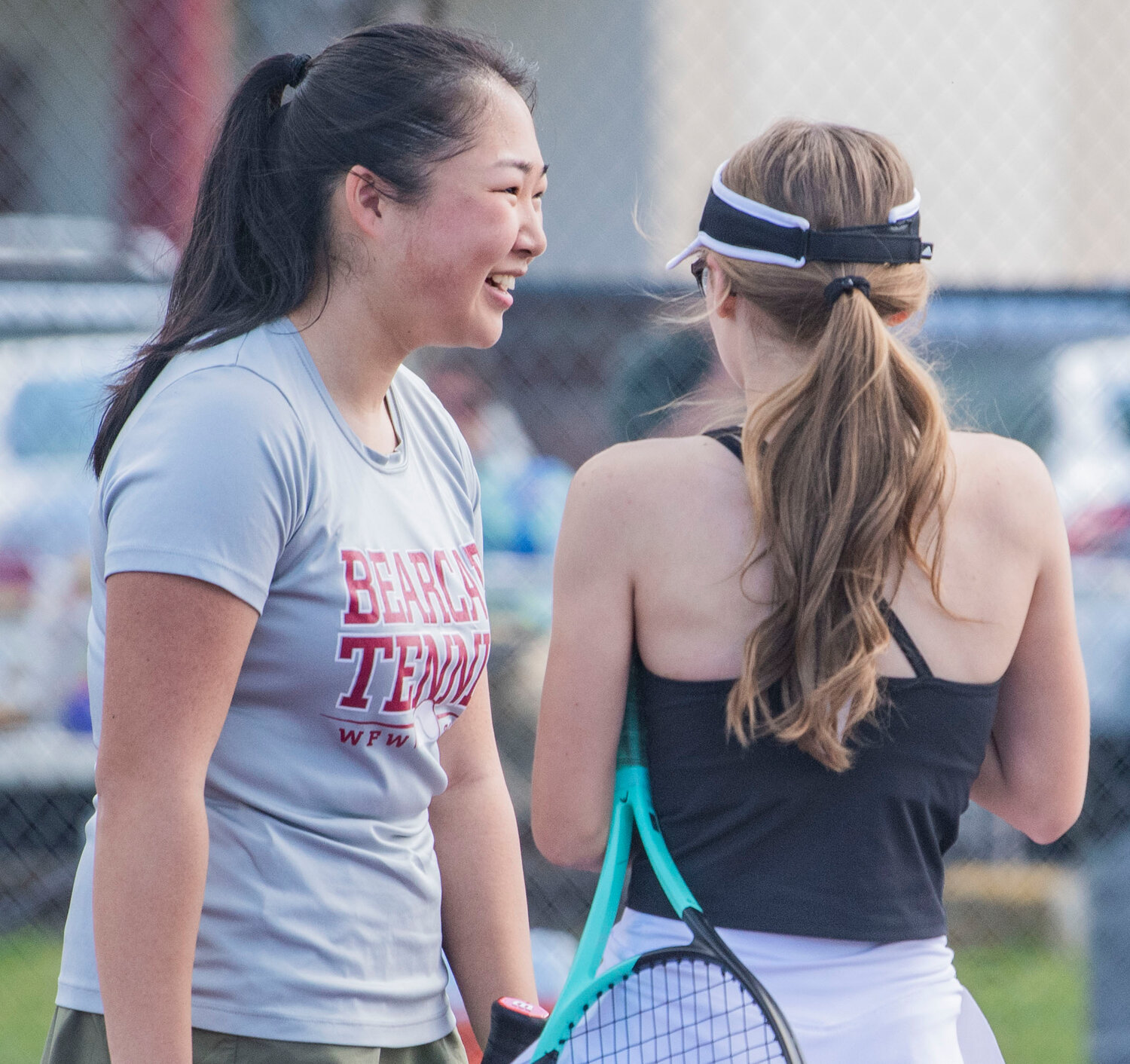 W.F. West first doubles player Laura Yip smiles while talking to partner Katelyn Wood during the Evergeen Conference league championship match Black Hills courts on Tuesday.