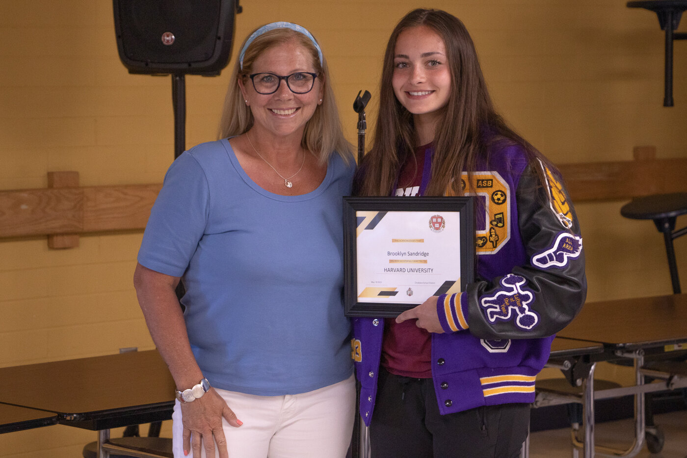 Onalaska School District board chair Tanya Naillon presents Brooklyn Sandridge with a congratulatory certificate for Sandridge's acceptance to Harvard.