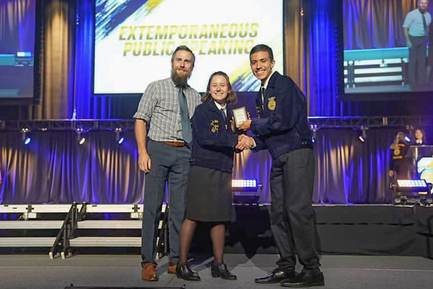 Ileana Wall, center, of the Yelm Future Farmers of America (FFA) chapter accepts her award for winning the 2023 Washington FFA state championship for extemporaneous speaker this past weekend in Kennewick. Photo courtesy of Washington FFA Association.