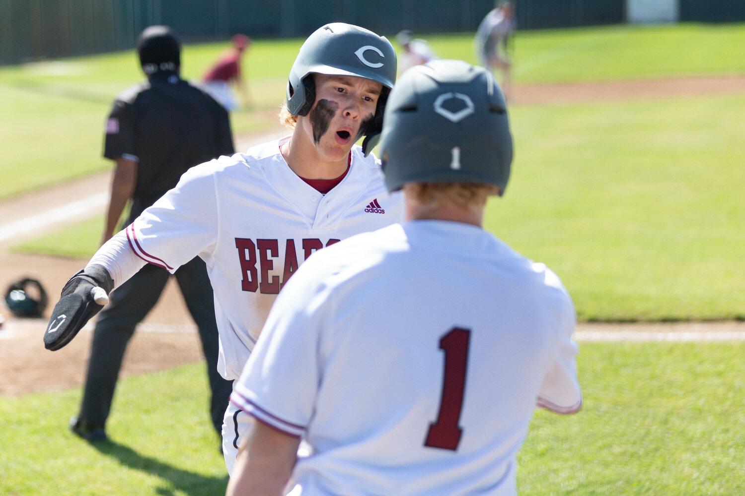 W.F. West's Deacon Meller high-fives teammate Ross Kelley (1) after scoring a run against Port Angeles in the opening round of state in Chehalis May 20.