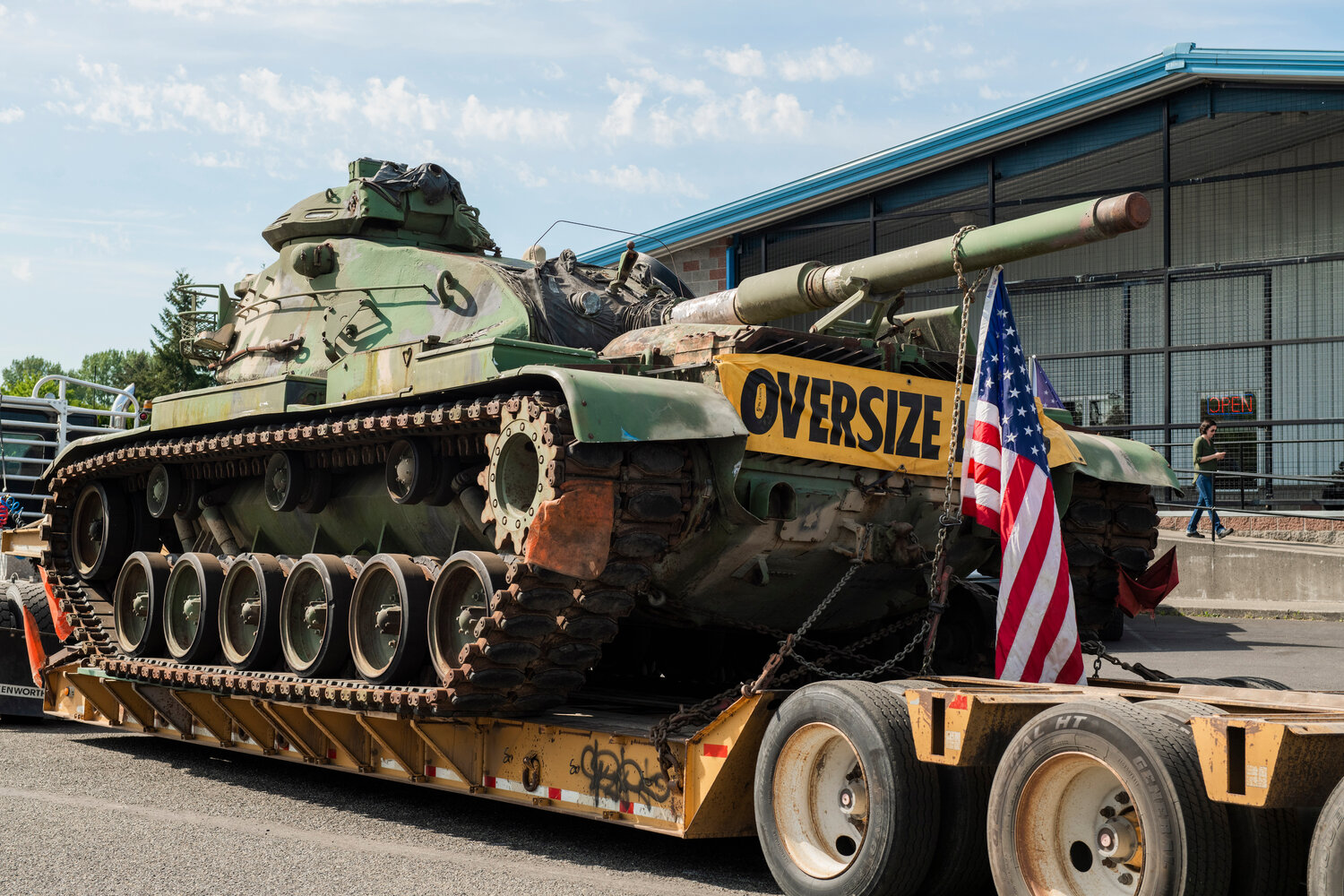A flag hangs from a M60 tank as it is hauled into the parking lot of the Veterans Memorial Museum in Chehalis on Saturday, May 20.