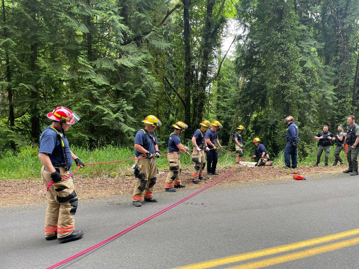 Crews from Cowlitz 2 Fire and Rescue work to pull a man from a ravine in Cowlitz County on Sunday.