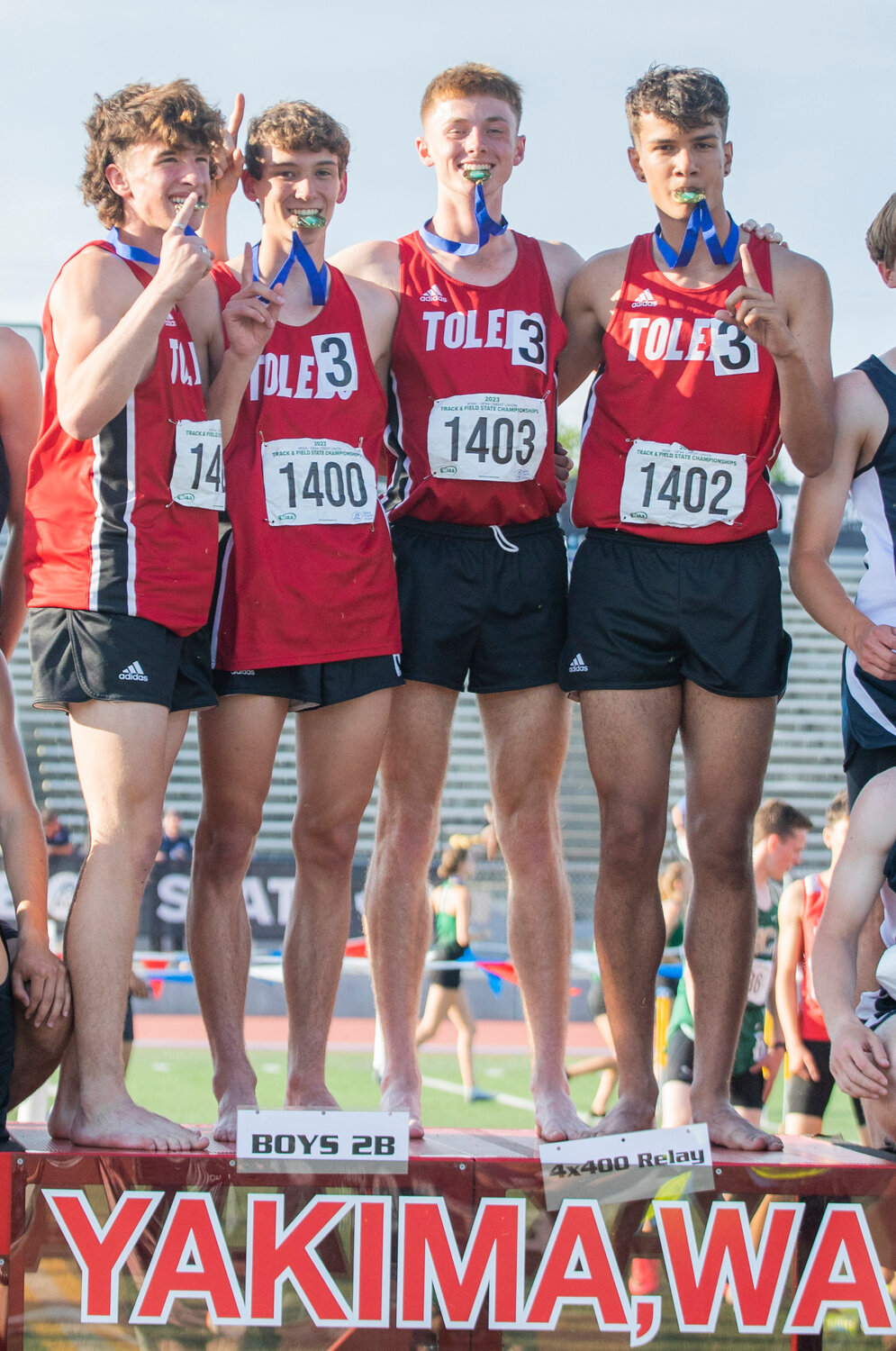 From left, Toledo’s 4x400 championship relay team, Trevin Gale, John Rose, Conner Olmstead and Jordan McKenzie pose with their gold medals atop a podium at the 2B State track and field meet in Yakima on Saturday.