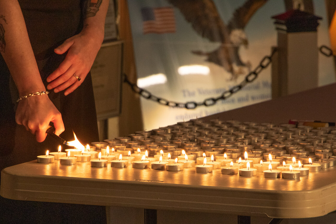 Kylie McKune-Dahl lights a candle in rememberance of each service member whose name hangs on dog tags on the branches of the Tree of Life at the Veterans Memorial Museum during a ceremony on Memorial Day.