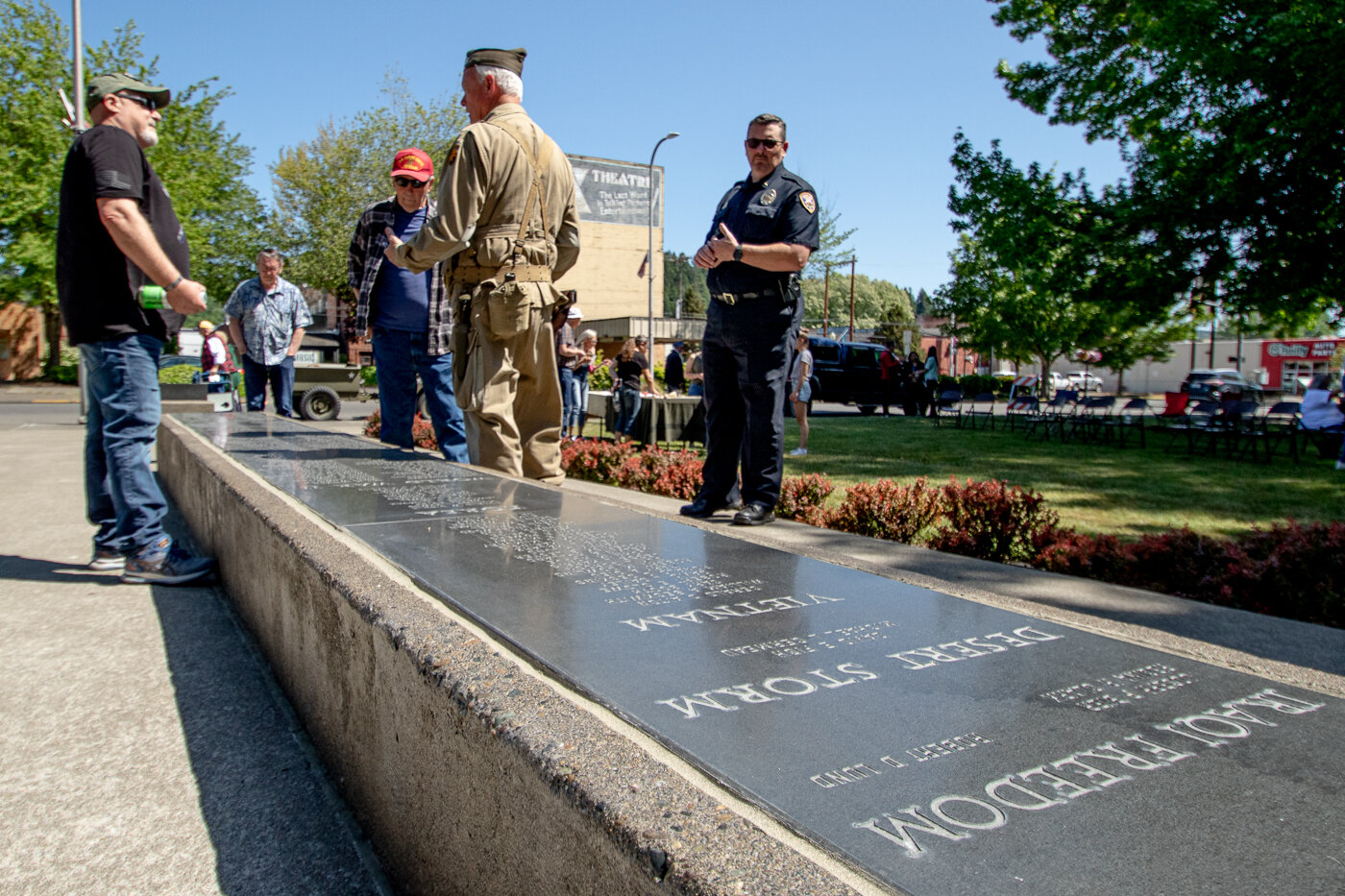 Lewis County Historical Society president Peter Lahmann talks with Memorial Day ceremony attendees on Monday about the 355 names listed on the Freedom Walk War Memorial at George Washington Park in Centralia.