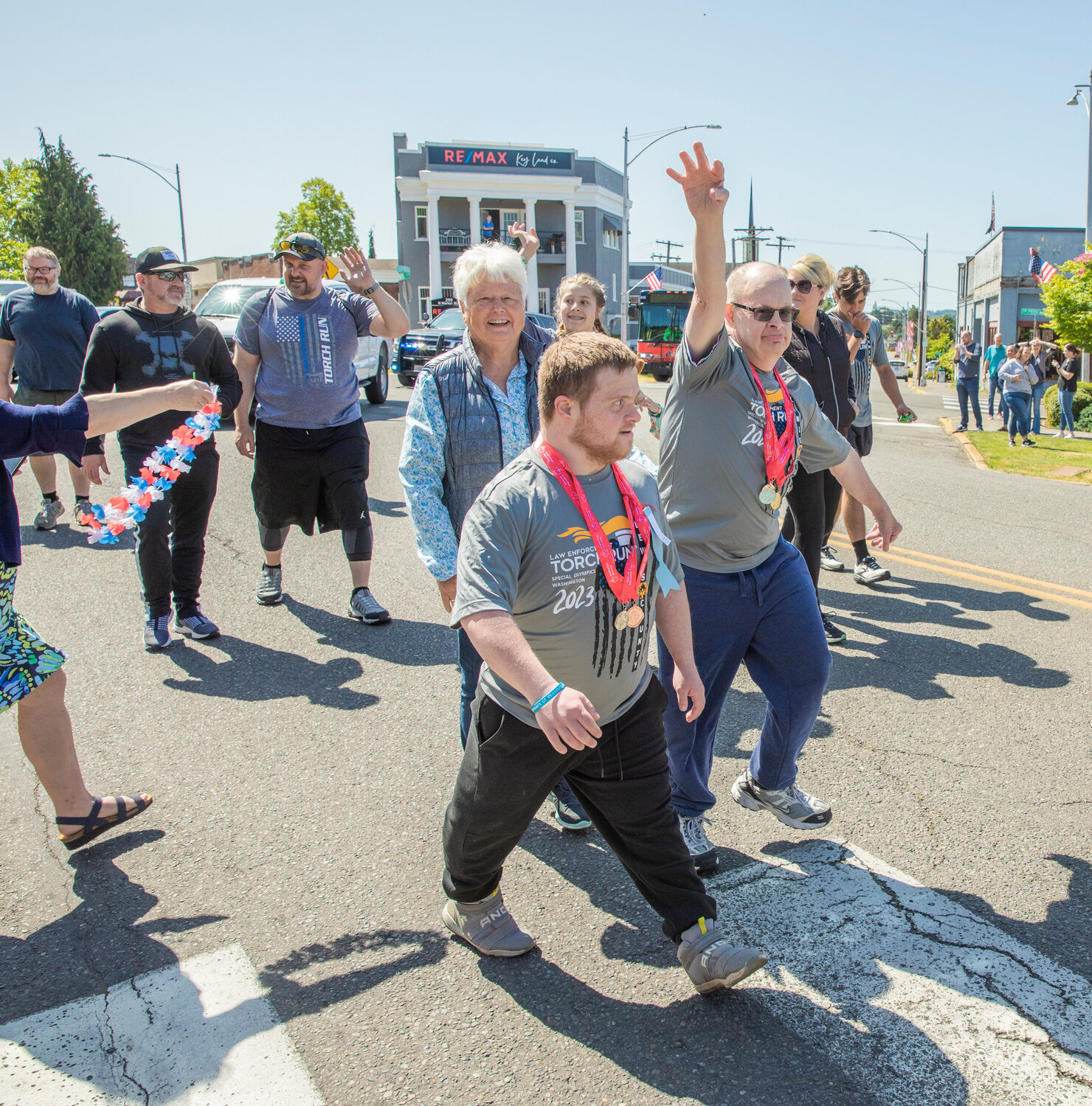 Participants wave to supporters during the Lewis County Special Olympics Law Enforcement Torch Run in downtown Chehalis on Friday, June 2.