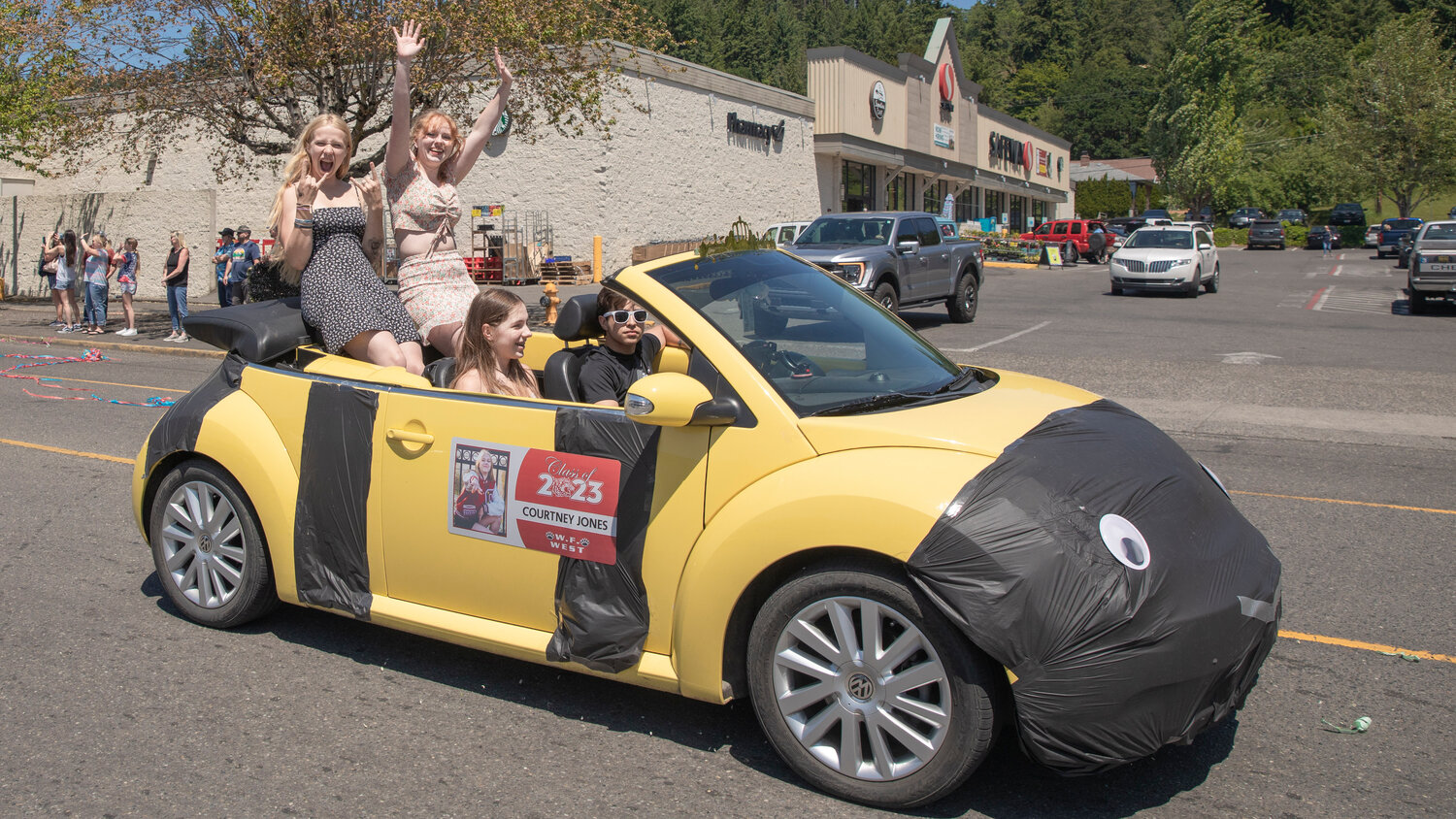 Courtney Jones and classmates smile and cheer during a parade honoring future graduates of W.F. West High School in Chehalis on Sunday, June 4.