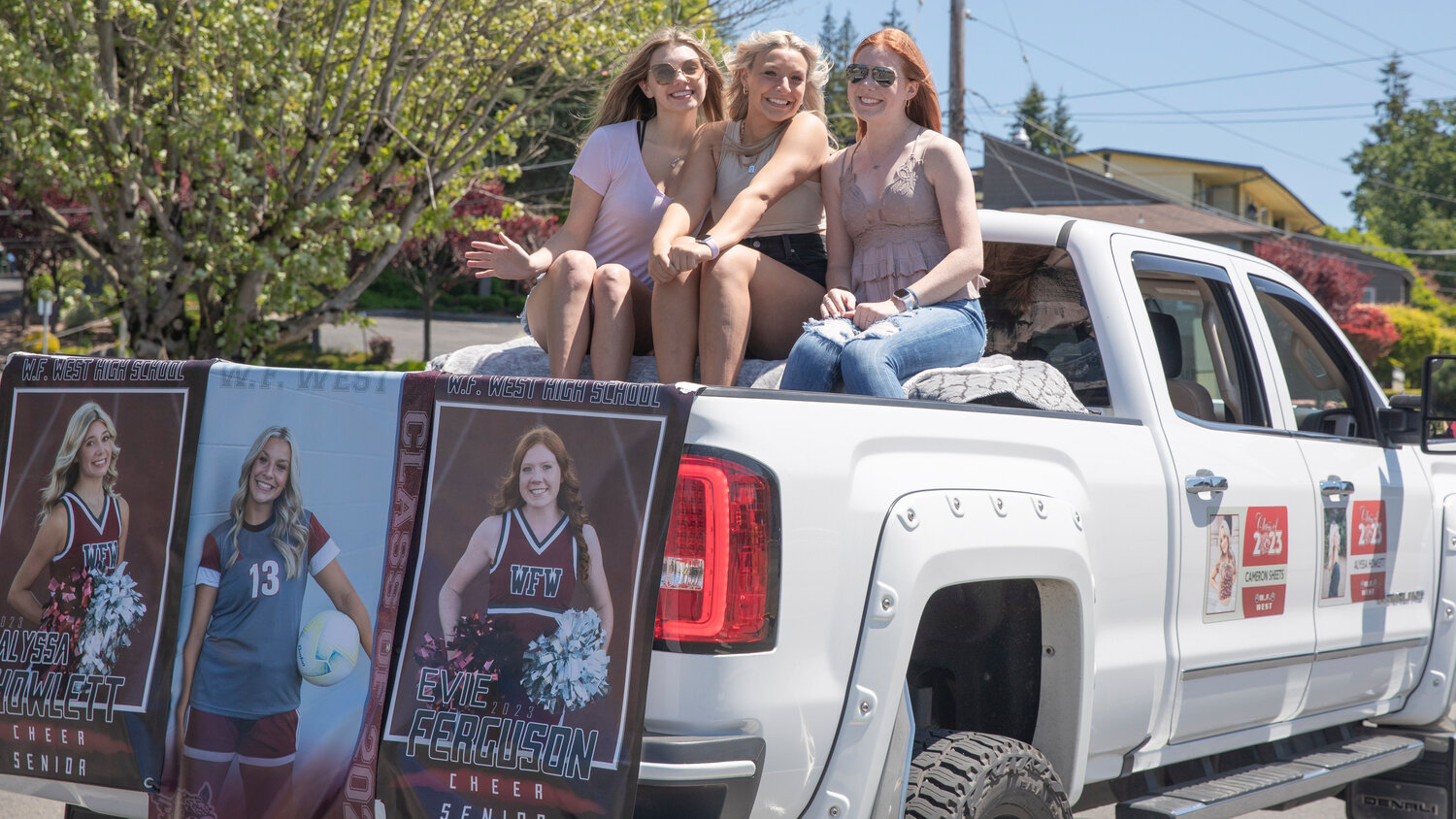 W.F. West High School seniors Alyssa Howlett, Cameron Sheets and Evie Ferguson smile for a photo during a parade honoring future graduates in Chehalis on Sunday, June 4.