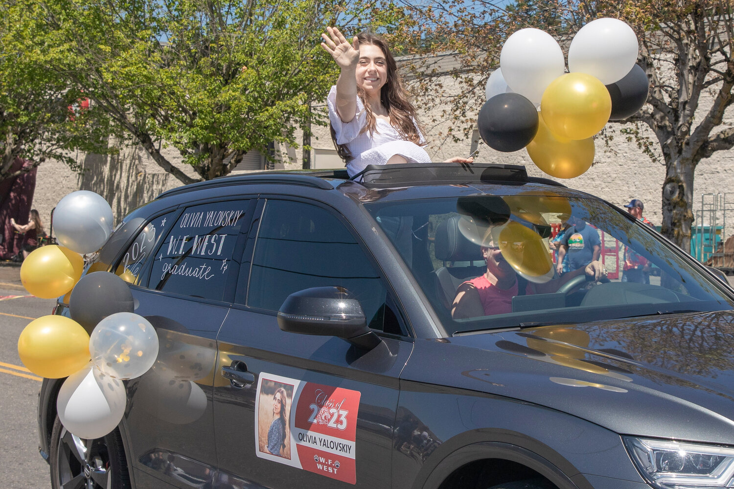 W.F. West High School senior Olivia Yalovskiy smiles and waves during a parade honoring future graduates in Chehalis on Sunday, June 4.