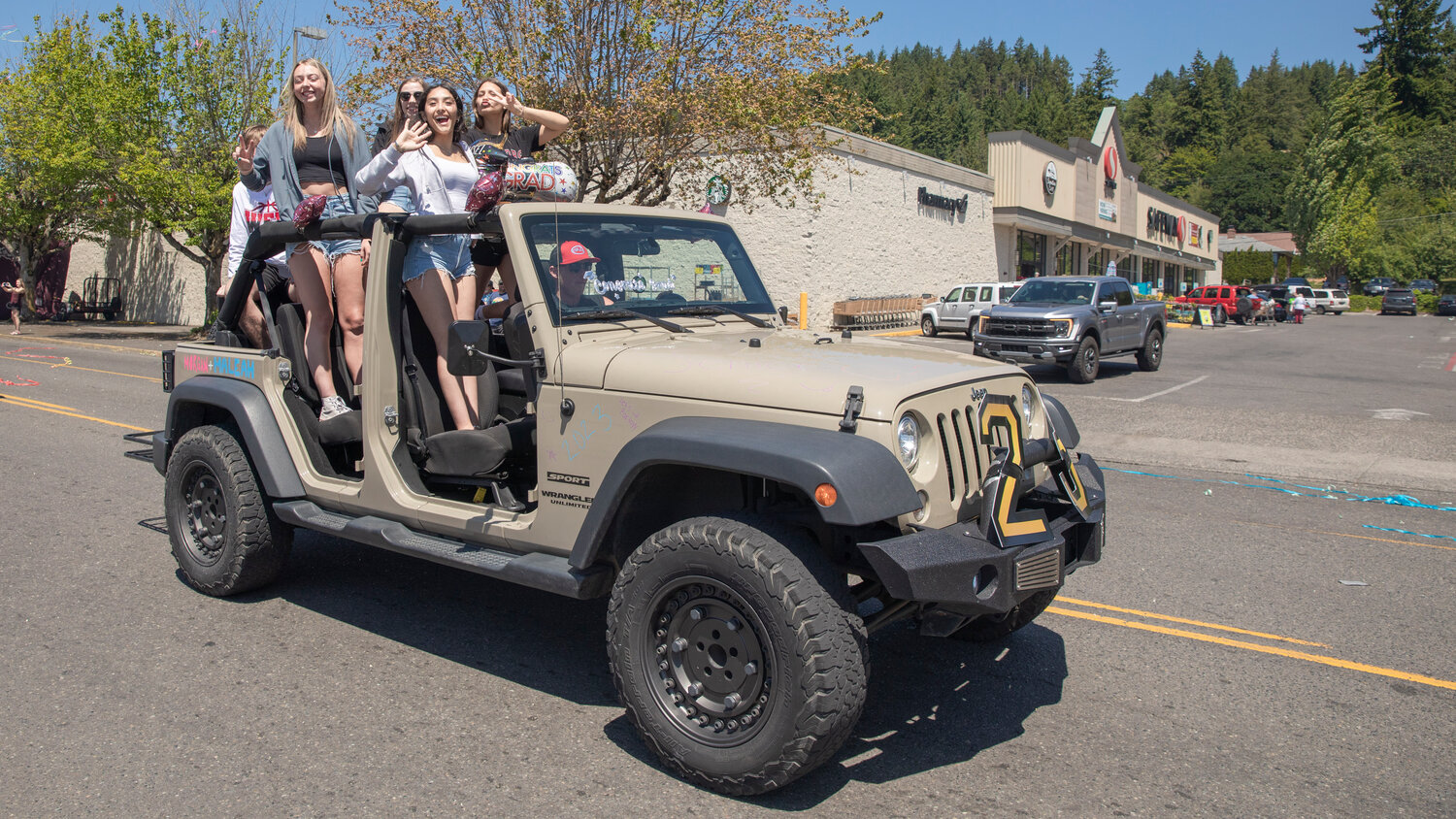 W.F. West High School seniors smile and stand in a Jeep rolling through Chehalis during a parade honoring future graduates on Sunday, June 4.