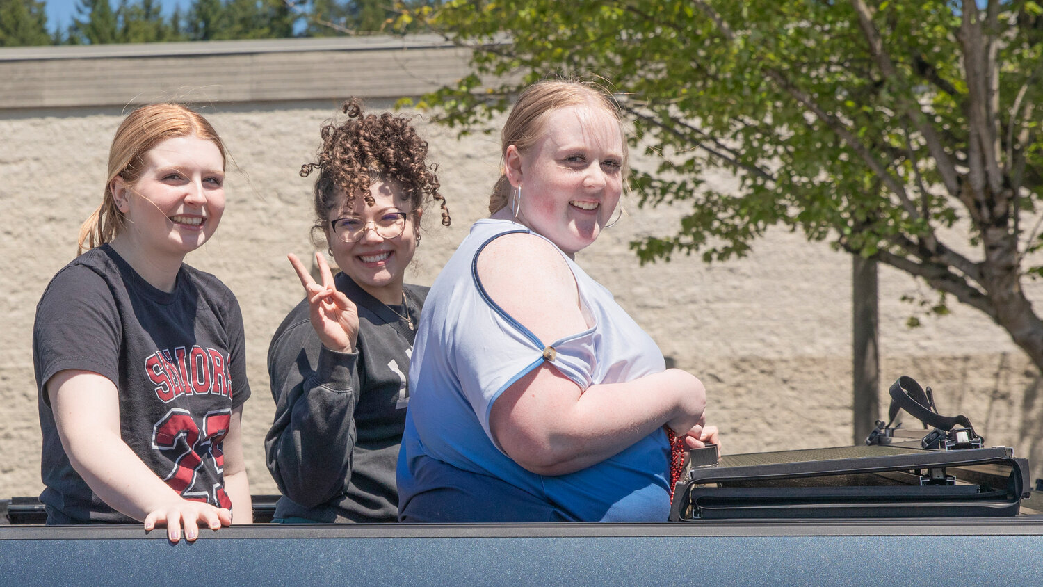 W.F. West High School senior Piper Chalmers smiles from the bed of a truck during a parade honoring future graduates in Chehalis on Sunday, June 4.