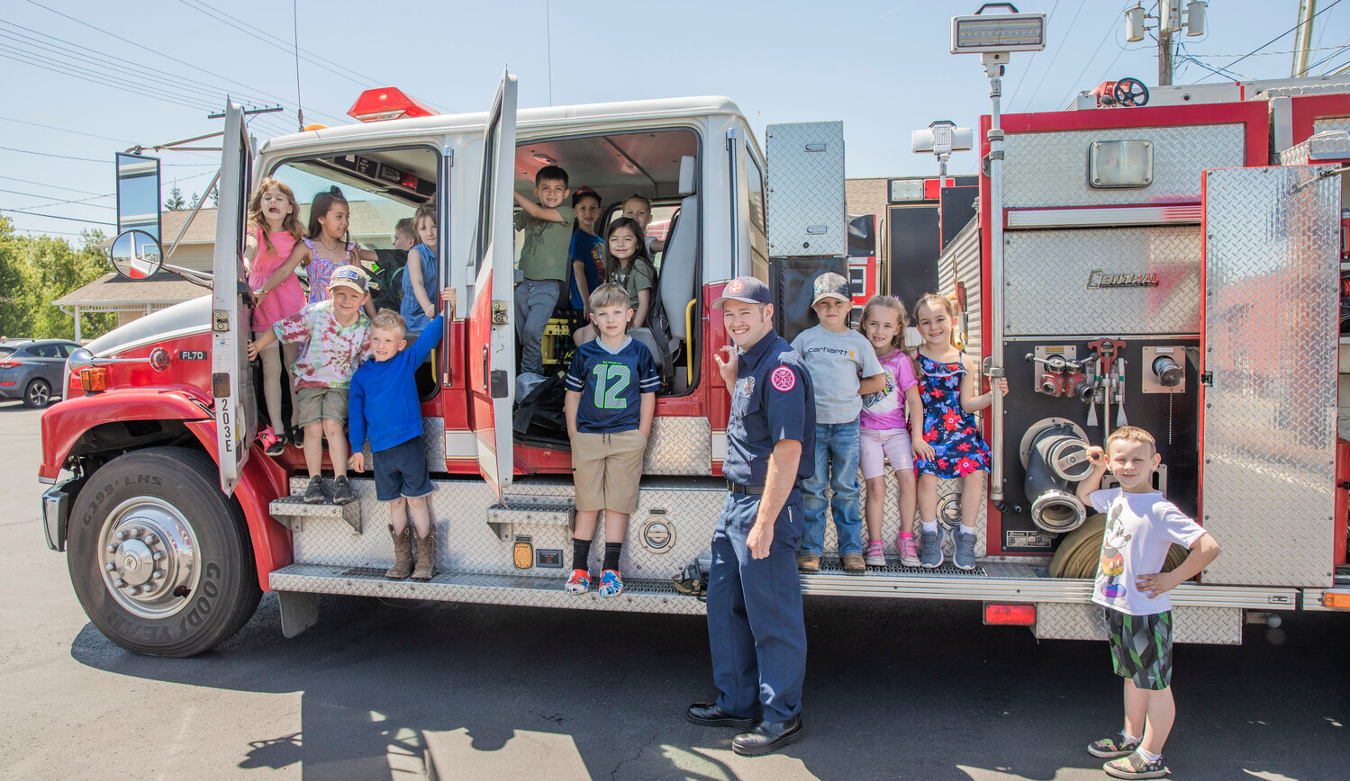 Kindergarten students pose for a photo while climbing in and around a fire engine during a visit to Lewis County Fire District 5 in Napavine on Tuesday, June 7.