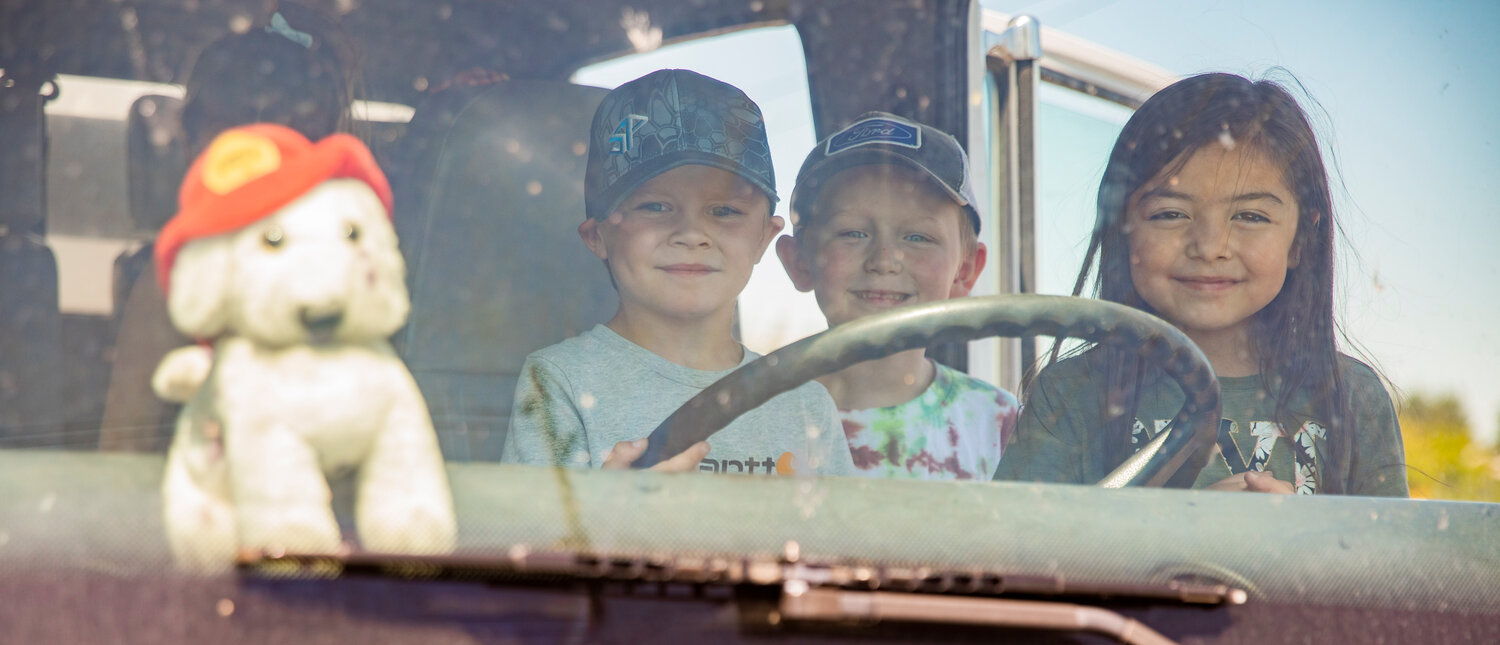 Kindergarten students smile behind the wheel of a fire engine during a visit to Lewis County Fire District 5 in Napavine on Tuesday, June 7.