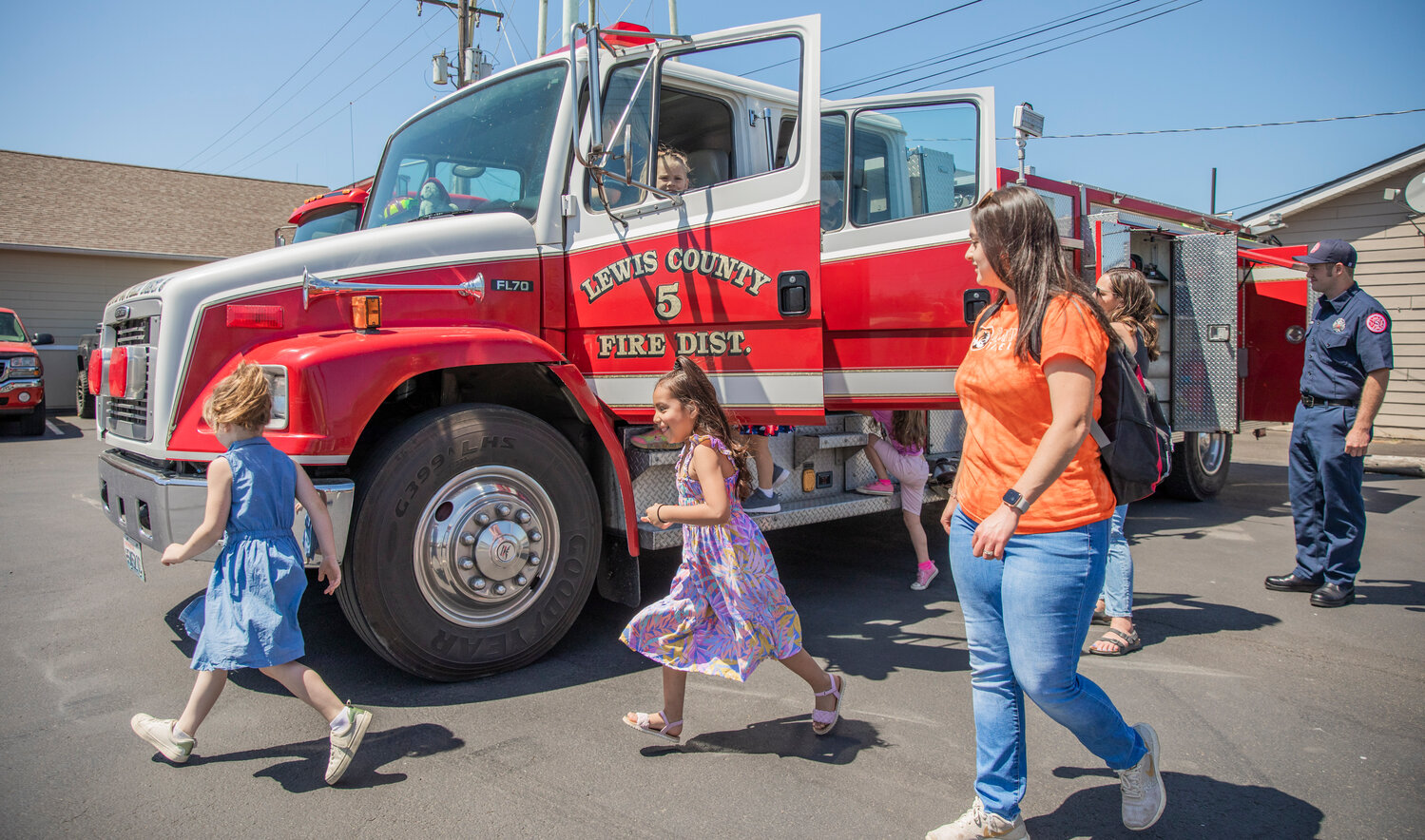 Kindergarten students run around and climb in a fire engine during a visit to Lewis County Fire District 5 in Napavine on Tuesday, June 7.